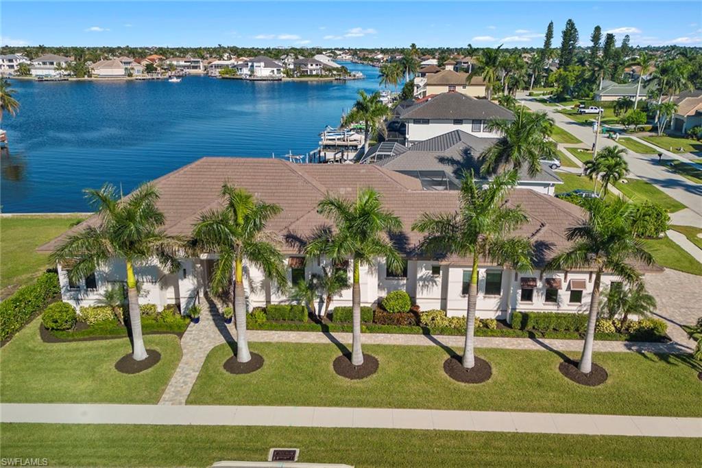 Spacious and coastal new construction modern style design is expertly crafted to enjoy all the Island life offers. The perfect blend of high-end details with an open and inviting layout that leads to expansive views of Landmark Bay. Located in the highly desired Marco Beach area and a short walking distance to the beach and restaurants, this home takes full advantage of the expansive water views and the sunrise skies. Gourmet kitchen opens toward the living areas, lanai, and water views, with a large walk-in pantry. Gorgeous floors, coffered ceilings, built-in cabinets, and an outdoor kitchen create a warm and inviting space for living and entertaining. Split floor plan with an elegant master suite, 2 guest en suites, & 4th bedroom or office to-suite. Sliders recess and fully open to extend the living space for backyard entertaining. Features upgraded lighting, custom window coverings, integrated indoor/outdoor system, spacious 1,800 sq ft lanai, large saltwater pool and spa. Quick out to the Gulf through the Landmark Bay. Ideal southern island location with spectacular views, convenient Gulf access, and close proximity to the Marco entertainment, dining, shopping & beach access.