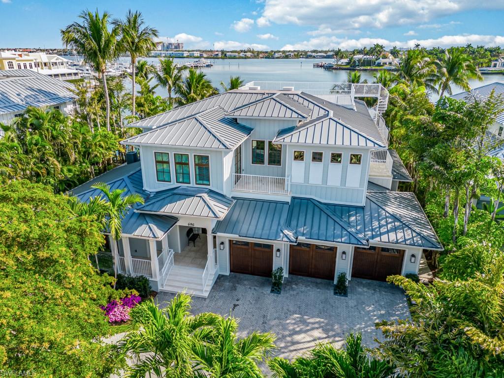 Introducing a rare opportunity to own a stunning home in the prestigious Aqualane Shores neighborhood in Naples, Florida.  Located at 696 15th Avenue South, this luxurious home boasts five bedrooms, six full baths and one half pool bath. The home features Acacia wood flooring, brand new designer furnishings, new & updated cabinetry, and Wolf, Miele, & Sub-Zero appliances and is being offered fully furnished for a move-in ready experience. With a three-car air conditioned garage, which offers ample space for vehicles and storage, as well as a golf cart.Brand new Full home generator system, Located on a private cul-de-sac, the coastal chic style effortlessly blends with waterfront elegance offering a sophisticated yet relaxed atmosphere. This home also features a dock with boat lift and is conveniently located next to the world famous Naples Yacht Club with direct deep water access to the Gulf of Mexico through protected Crayton Cove. Relax by the fabulous pool and covered lanai while taking in the sights and sounds of the best that Naples has to offer. Enjoy the convenience of walking to the best restaurants on Third Street, taking a golf cart ride to Fifth Avenue South & gorgeous beaches, or setting sail to any destination in the world from your private dock. This fabulous home is a true gem nestled between Old Naples and Port Royal. With no bridges to navigate, you can reach your desired destinations within minutes. Don't miss this incredible opportunity to own a piece of paradise in one of Florida's most coveted locations.