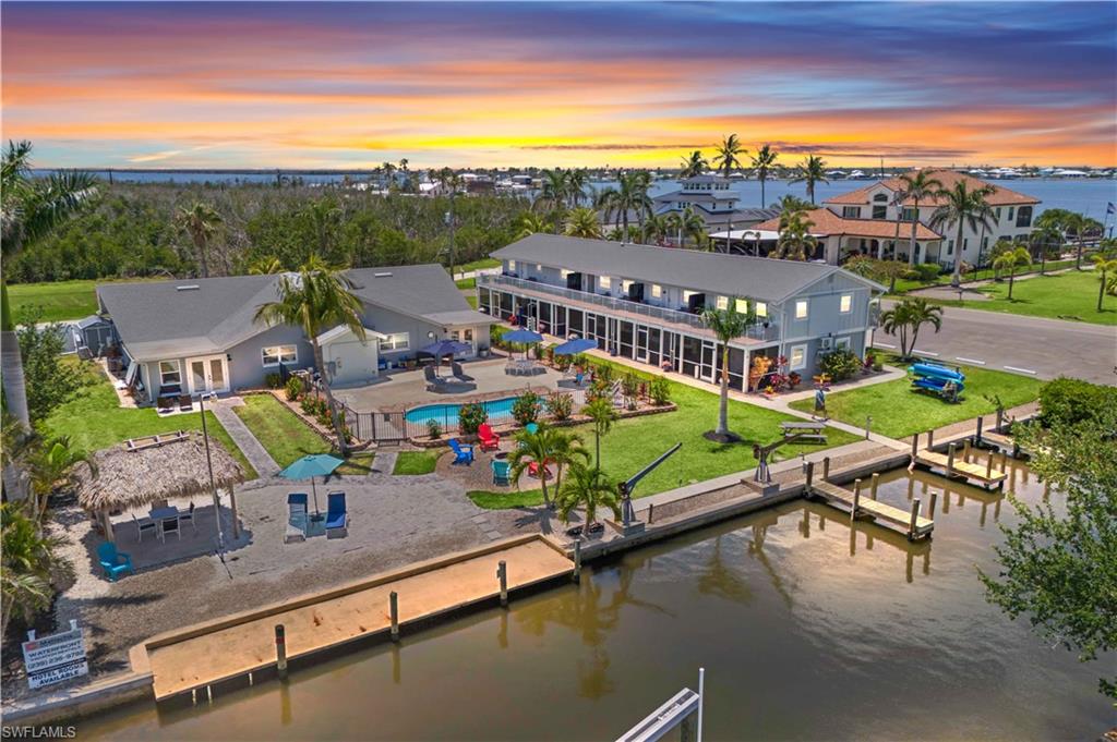 An amazing opportunity to own a unicorn property with SO much potential and so many different options. Take advantage of this opportunity to build and expand upon current owner upgrades - this resort property is located in Matlacha, a renowned old Florida art and fishing village with easy access to Cape Coral, Pine Island and the multiple surrounding islands and also located directly on the Great Calusa Blueway - a 200 mile guided
kayaking and paddling water trail. Matlacha is known for its Olde Florida community, tourism and some of the best fishing and boating right in your back yard, with endless views, a nature lover's paradise. Over 275 feet of water frontage, endless views, 5 boat slips (could be 6), magnificent potential and currently used as a short term vacation rental/hotel. Total Units: 13 units plus one office option(convertible to a 3rd bedroom in Unit 2
of the quad)and mirrors the 3-bedroom layout in Unit 3. Two buildings - Two-story building: 9 units (2× 2BR, 6× 1BR, 1 hotel room currently used as laundry), Single-story building: 1× 3BR, 1× 2BR, 2 studios, Square Footage: 7,400 SF (4,650 SF + 2,750 SF), Land: 1 Acre, direct waterfront, Zoning: multi-family / hotel. This was fully renovated in 2025 and is in spectacular condition - attention to detail in all upgrades and this entire
property and each unit is spacious, with upscale decor and furnishings. Investment Highlights / Projected NOI (Year 1): $311,500 (Financial Overview and Proformas available upon request / Pro Forma Cap Rate: 6.9% / Revenue Potential: $550,000+ annually at 70% occupancy / ADR Growth: $180 - $210 projected over 5 years / Expansion Potential: Opportunity to add RV spots or tiny homes in the gravel area along the canal / convert laundry/office space to additional guest accommodations or amenities. Potential additional revenue streams include event hosting, day passes, boutique retail store, kayak rentals, bike rentals, jet ski rentals - additional detailed floor plans, unit information and financials available. All the work has been done and ready for a new owner!
