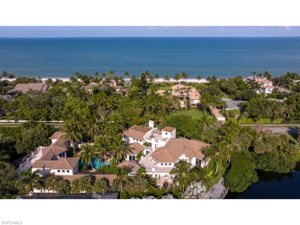 One of the most magnificent estates in Old Naples! Designed by Herscoe Hajjar Architects, LLC and masterfully constructed by A. Vernon Allen Builder, Inc., the residence blends harmoniously into its enchanting lakeside setting nestled along Gulf Shore Blvd. The interior living spaces are well configured, without loss of focus on the glorious natural surroundings. Vast opportunities for outdoor entertaining around the expansive and extraordinarily private pool, covered terraces, and rooftop decks. The primary bedroom suite is located on the first floor with two additional bedrooms located in the main residence. The fourth and fifth bedrooms, accompanied by an additional living room, are located in the guest wing of the home. 4 Garage Bays. Conveniently located, while retaining the charming attributes of a very private retreat.