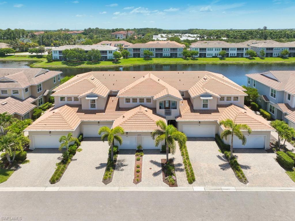 Rare First-Floor Pond View — The One Worth Seeing at Arboretum! With no shortage of options, the difference is in the details — and this one has all the right ones. First-floor living is rare in this 246-home community, and a pond view instead of a wall or road is rarer. The Delmar floor plan with upgraded finishes, no carpeting, and custom wall treatments. This 1,341 sq. ft. two-bedroom, two-bath unit has been thoughtfully elevated above the entry level standard. Wood-look luxury vinyl flooring runs throughout, the kitchen delivers quartz countertops, a large island, Whirlpool appliances, and a walk-in pantry, and the screened lanai opens to serene water views that make every evening feel like a retreat. The primary suite offers dual vanities, a frameless shower, walk-in closet, and direct lanai access. Attached garage, large laundry room, and no flood insurance required. Arboretum is gated, pet-friendly (large dogs welcome), and loaded — resort pool and spa, fire pit, fitness center, dog park, and HOA-included cable and WiFi. Minutes from Fifth Avenue, Gulf beaches, the Botanical Garden, and East Naples' world-class pickleball.