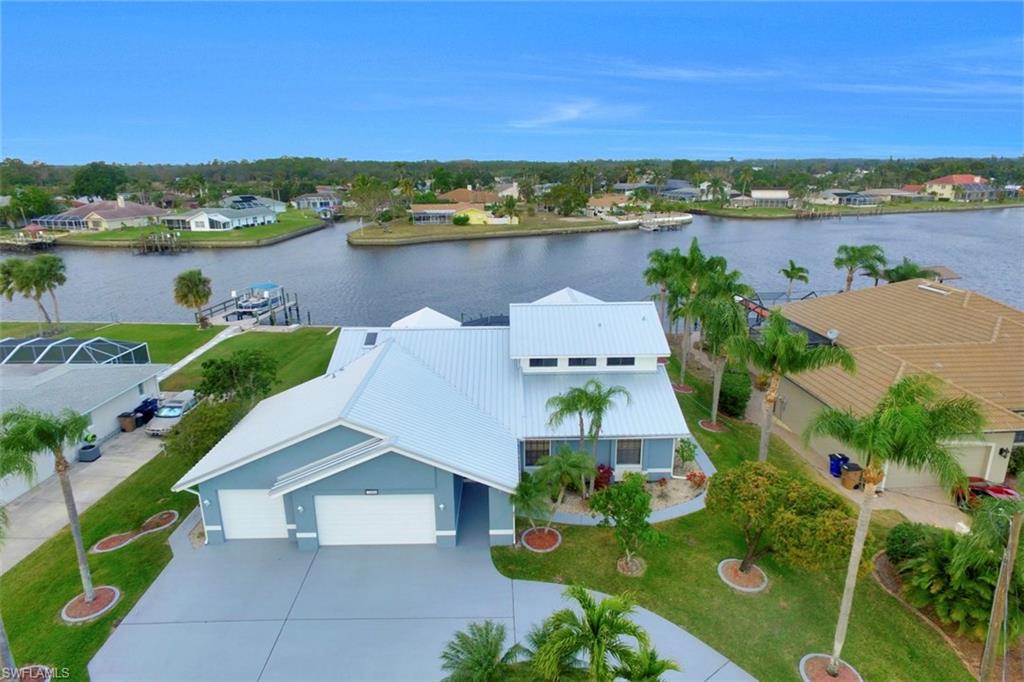 Big Riverfront Water Views & Direct Boating Access. Riverfront views throughout this large pool home. Featuring 4 bedrooms, 3 bathrooms, a 3-car garage, high soaring ceilings, and incredible views of the River & basin. NEW METAL ROOF & POOL CAGE! Oversized lot with 100 feet of seawall & 65 feet of dock space with newer dock and 2-year-old 10K pound boat lift w/ power+water for direct boating access. Family & dining rooms with high cathedral ceilings and expansive water views. Kitchen upgraded with granite counters & skylights for natural lighting. 352 sq.ft. enclosed sunroom has offers a 360-degree views in all directions of multiple intersecting canals, the basin, and the river! With a small AC added to sunroom this home could be nearly 3,000 living area! 2 master bedrooms (1 downstairs & 1 upstairs) both w/ river views & balcony upstairs. Generous sized spare/guest bedrooms. Huge solar heated pool & patio/lania overlooking the water and private dock. Prewired for hot tub, generator hook up in place, 6x12 storage room off the garage for workshop or office. Impeccably maintained original owner, with numerous custom features added when built. Size, views, and instant boating access!