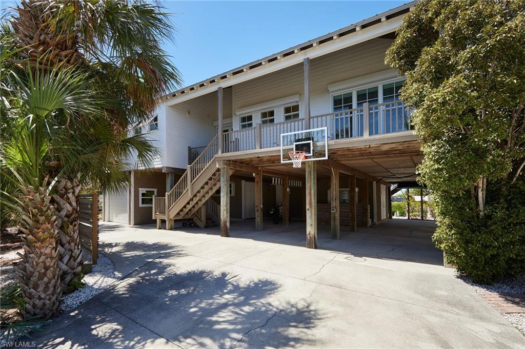 Stunning, Custom Coastal Canal Home located in Captain’s Cove Community--- just minutes to open water.  Note that the Captain's Cove community offers a community boat ramp, dock and community sewer system.  No individual septic tanks.  The original architectural design features include; home built on 47 10" pilings, 10’ ceilings, unique 8’ plantation-style doors with ventilation louvers and 8’ glass doors that open onto the upper deck creating a luxurious West Indies vibe that gives a grand, airy feel to this home that continues out to the wood-ceilinged balcony, where the breeze is constant and the view of the canal is wonderful.  The floor plan includes two bedrooms up and one bedroom down with two additional rooms (one utilized currently as the 4th bedroom).   Finish features of the home include tropical Peruvian Cherry hardwood floors with 7” baseboard, tiled baths, and large laundry room. The chef’s kitchen offers two ovens, high end appliances, Viking Range Hood and much more!  Under home parking is one inside garage space and 3 additional carport spaces!  Sellers added the following features to the home; a second walk-in primary closet with media/entertainment tower, a spacious/one car garage with storage area, an additional 50A station for your electric vehicle, privacy fence to accommodate an HOA approved parking space for your RV/motorhome with 50A hook up, boat dock the full width of the property, 8000 lb covered boat lift, all the manual and electric storm shutters in addition to modifying the Bahama shutters such that they may be secured from inside the home!   Above ALL this home has been safe, dry and secure from every storm that's tested it! This home had absolutely no flooding or damage to the structure or enclosed spaces from ANY hurricane.  You can rest easy in knowing your home is secure and ready to lock and go.  This beautiful property is a must see whether you’re a gulf access boating/fishing enthusiast or just a sun-loving beach hopper!