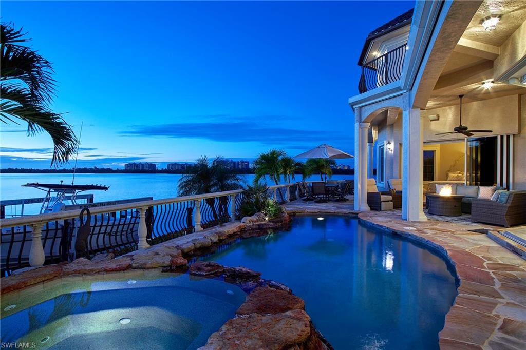Enjoy magnificent views with 149' of water frontage on Collier Bay. This key lot Custom built estate offers direct access, with western exposure for spectacular sunsets. Enter this stunning home through 18’ wood framed double doors into the open living area with 22” ceilings and marble flooring, fireplace and pocket sliders opening the living area into a fabulous pool area and highlighting the incredible views. A spectacular staircase cascades to the loft area overlooking the living room with panoramic views of the bay and second level with observation tower at the top of the residence! The main level hosts the gourmet kitchen and dining area with light raised panel cabinetry and granite countertops, top of the line stainless appliances and a convenient island. The master bedroom is spacious with sitting area and bay views. This elegant residence offers designer moldings, large windows and tray ceilings throughout. The pool and spa are finished with a decorative stone border and iron and concrete railing surround. You will love the ground level lounge and sun deck overlooking the water! Complete with 110’ dock with 16,000 lb lift plus 2 jet ski lifts, kayak lift and 3 car garage.