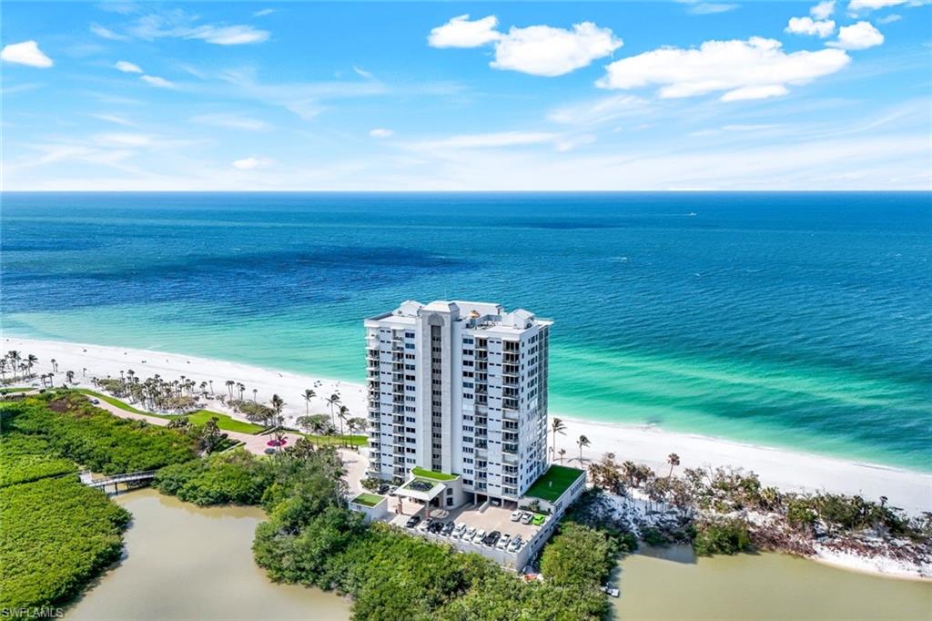 Once in a while, an extremely rare and unique real estate opportunity comes along, and the PH2N at the Seapoint of Naples Cay is one of those opportunities.  New to the market after 25 years, this 2 story penthouse unit offers unobstructed views of the Gulf and Clam Bay to the north. A most incredible feature is the 1,000 Sq Ft private rooftop deck and covered outdoor kitchen.  The wrap around glass railing provides a sense of floating on water.  A powder room and sauna complete the upper level. On the main floor, the great room offers captivating gulf views through floor to ceiling windows, and the oversized lanai with electric sliding glass doors facing west AND north creates an amazing indoor/outdoor living space to enjoy the best of SW Florida’s sunsets. The views continue to the kitchen and morning room, where a built-in work space offers wide views of the natural preserve.  As the bay wraps around the building, the extraordinary den/library featuring wood paneled wall and ceiling detail, and 2 guest rooms enjoy the serene beauty of Clam Bay.  Befitting the best unit in the building, an oversized 2 car garage under the building comes with this unit. The Seapoint at Naples Cay spoils their residents with top notch management and 24 hour concierge-like security staff.  A resort style pool overlooking the beach, a quality fitness center, luxurious social room and 2 guest suites are available on site for the exclusive in this low density building of 28 residences. Taking storm protection to the next level, a flood gate system helps to protect the building against storm damage.  Naples Cay is a gated condominium development with manned security.  Located at the end of Seagate Dr., this beachfront location offers quick access to Venetian Village, Waterside Shops, Artis and all that Naples has to offer.