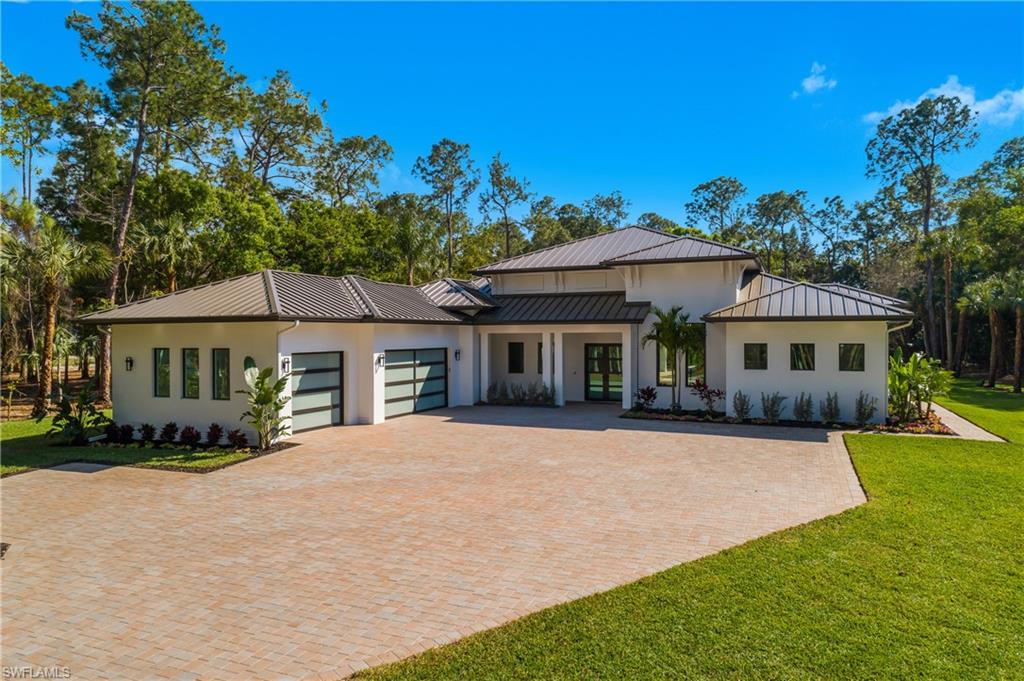 Private 2.27-acre gated estate in Logan Woods offering rare acreage, privacy, and new construction convenience in a central Naples location. Completed in 2026 as a custom builder’s personal residence, this thoughtfully designed single-story home features 3,989 square feet under air with 4 bedrooms, 4 full baths, 1 half bath, and 14-foot ceilings throughout.

The expansive great room opens seamlessly to a designer kitchen appointed with quartz and granite surfaces, custom cabinetry, premium appliances, and a concealed butler’s pantry. Walls of sliding glass create effortless indoor-outdoor living. The primary suite is privately positioned and includes a fireplace and spa-style bath with steam shower, soaking tub, dual vanities, towel warmer, European body dryer, and separate custom walk-in closets. A glass-enclosed office or wine room adds flexibility and architectural appeal.

Outdoor living is designed for year-round enjoyment with a covered lanai fireplace, fully equipped summer kitchen, saltwater pool and spa with fire and water features, travertine decking, and outdoor shower, all surrounded by preserved trees for natural privacy.

Notable features include a 1,000-gallon underground gas tank, whole-house generator, reverse osmosis system, spray foam insulation, impact windows and doors, metal roof, zoned HVAC, glass garage doors, oversized 3-car garage, motor court, and fully fenced gated perimeter.

Conveniently located near I-75, approximately 10 minutes to Gulf beaches, and close to Mercato for upscale dining, nightlife, and entertainment.
