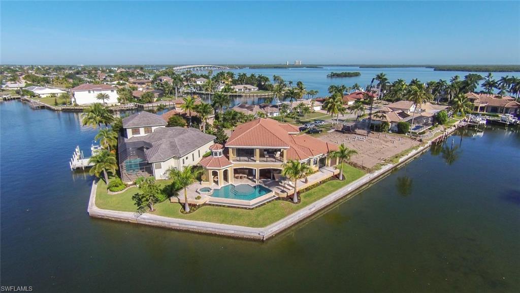 You must see this rare offering on Marco’s beautiful Tarpon Waterway. Highly desired SOUTHERN exposure! Beautiful tip lot residence expertly designed to maximize incredible waterfront views & sunshine! Luxury upgrades you'd expect PLUS: 'smart home' w/ the best modern technology, open floor plan, breathtaking views from expansive living areas out towards the infinity edge pool & beyond, fine wood craftsmanship throughout, especially showcased in gourmet kitchen w/ custom cabinetry, exotic granites, built-in Subzeros, Wolf & Meile appliances, awesome from the top where every volume ceiling was specially designed to the bottom w/ exclusive walnut & travertine flooring. 1st floor master bedroom suite overlooking bay w/ amazing bath. 4 bedroom home w/ 1st floor guest quarters & luxurious office loaded w/ wainscoting. Grand staircase to media room, 2 more en suites & vast balcony to enjoy the waterfront. Luxury travertine on lanai along pool deck & living areas & outdoor fireplace, summer kitchen, new 175’ foot seawall w/ exclusive waterfront views, minutes to the River & direct access to Gulf! 3-car garage, impact glass & electric shutters. Brand new boat dock & lift!
