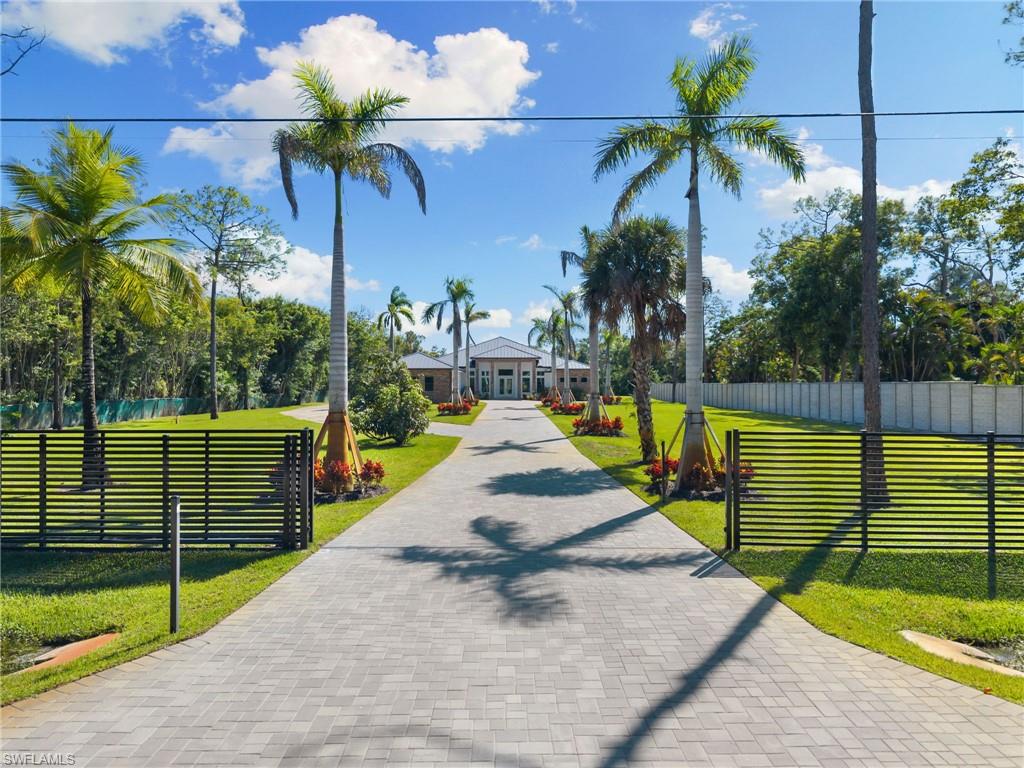 2025 LUXURY NEW CONSTRUCTION ESTATE ON 2.27 ACRES IN NAPLES’ COVETED LIVINGSTON WOODS! A rare opportunity to enjoy the privacy of acreage with no HOA—offering endless possibilities to add additional amenities or living space! Enjoy peaceful, South-facing wooded views surrounded by natural beauty. This contemporary masterpiece features 4,808 sq ft under air, 5 bedrooms + separate den/flex room, 5.5 baths, a 3-car garage, a whole-house reverse osmosis water system, hurricane-impact windows and doors, and a metal roof. Every detail was thoughtfully curated—from the wood-look tile flooring and soaring ceilings with rich custom wood beams to the modern chef’s kitchen featuring quartz waterfall countertops, dual-toned white and walnut cabinetry, stunning wood paneling accents, high-end appliances, and a hidden butler’s pantry. The formal dining area is ideal for entertaining, complete with two beverage coolers and custom built-in counters and shelving, while dual living areas each feature electric fireplaces. Step outside to your private outdoor oasis with an expansive entertainment deck, resort-style pool with tanning shelf and bubbler features, spa, summer kitchen, and covered lounge area with fireplace—perfect for gatherings or relaxed al fresco dining. The luxurious primary suite offers direct access to the pool deck and a spa-like bathroom adorned in marbled tile, complete with dual vanities, an oversized shower, and a freestanding soaking tub. Additional highlights include a private gated entry and electric vehicle charger. Livingston Woods is the perfect setting to enjoy peaceful acreage and convenience—located in an “A-rated” Collier County school district and minutes from Vanderbilt Beach, Waterside Shops, Mercato, and the world-class shopping and dining of 5th Ave and 3rd Street South.