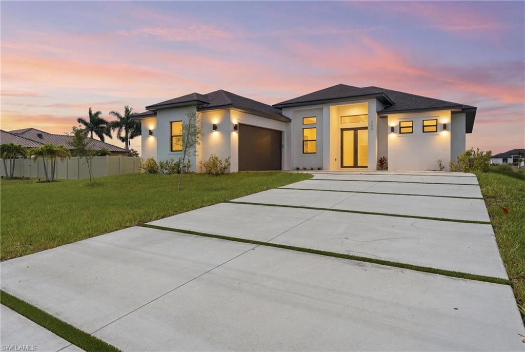 Experience contemporary waterfront living in this beautifully designed new construction home offering 3 bedrooms plus a den, 2 bathrooms, and 1,810 sq. ft. of thoughtfully designed living space. Situated on a freshwater canal with a concrete seawall already in place, this home perfectly combines modern style with everyday comfort. The striking white stucco exterior, dark roof, and elegant oversized concrete driveway create exceptional curb appeal. Inside, the open-concept floor plan is filled with natural light and features soaring tray ceilings, large-format tile flooring, and a spacious living area that flows seamlessly into the designer kitchen. The kitchen showcases white cabinetry, quartz countertops, a large center island, and sleek modern finishes. The private primary suite offers a spa-inspired bathroom complete with a freestanding soaking tub, oversized glass-enclosed shower with matte black fixtures, dual vanities, and abundant natural light. Step outside to the covered lanai featuring an outdoor kitchen, creating the perfect space for entertaining or relaxing while enjoying peaceful canal views. Additional features include a 2-car garage, impact-resistant windows and doors, contemporary finishes throughout, and an exceptional location close to shopping, dining, schools, parks, and everything Cape Coral has to offer. Connected to City Water & Sewer, Move-in ready and designed for the Florida lifestyle you've been looking for. Preferred lender offers up to $3,000 towards closing costs. Seller may offer additional incentives. NO HOA