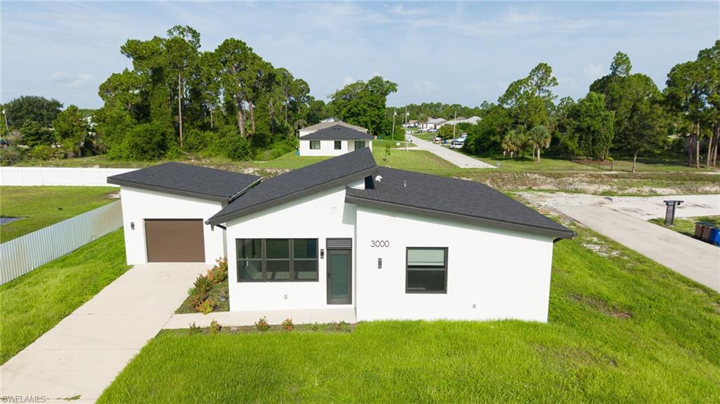 Welcome to modern Florida living in Southwest Lehigh Acres! Built in 2023, this 3-bedroom, 2-bathroom single-family home features a sleek single-car garage and striking modern architectural lines. Inside, an open-concept layout with high ceilings and large-format tile flooring creates a bright, airy ambience throughout.  

The heart of the home is a chic kitchen complete with high-gloss white cabinetry, quartz countertops, stainless steel appliances, and a breakfast bar for easy entertaining. Enjoy total peace of mind with full impact-resistant windows and doors that fill every room with natural light.  

This Beautiful sits on a spacious 0.27-acre lot with no HOA fees, you'll have all the backyard space you need. Plus, with quick access to State Road 82, commuting to Fort Myers, shopping, and dining is a breeze. Perfectly suited as a primary home or a low-maintenance investment property!