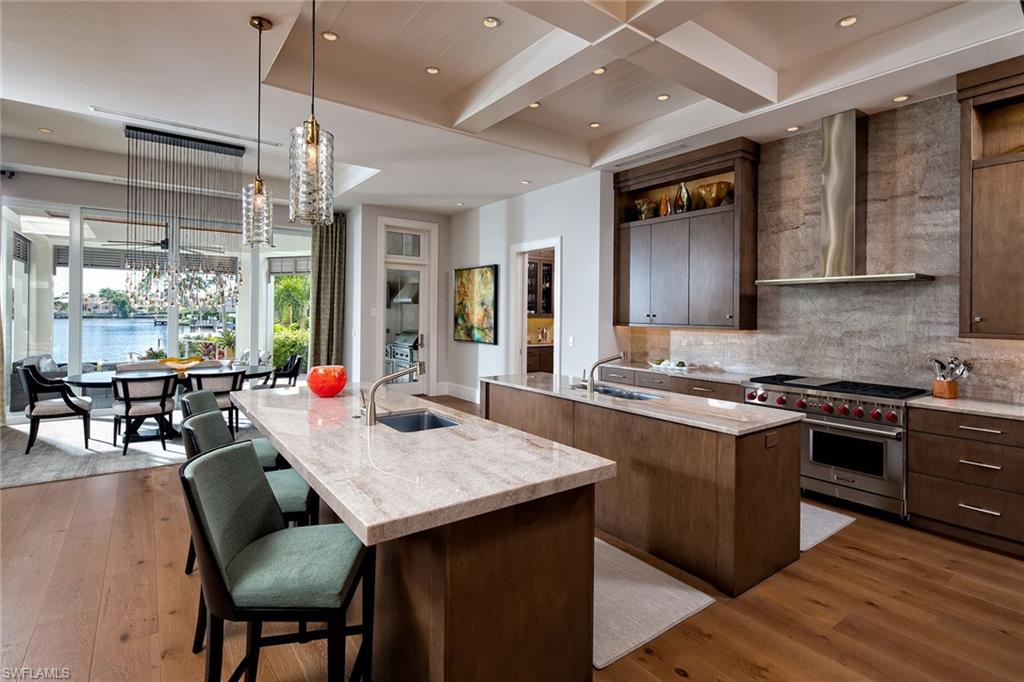 Coveted southern, long-water views captivate you as you enter this lovely Venetian Bay home. With water views from almost every room as well as patio doors that open expansively to the outdoors, this home becomes the ultimate indoor/outdoor entertaining residence. Featuring European white oak floors throughout, Sub-Zero and Wolf appliances and custom Ruffino cabinetry, this transitional gem is filled with high end finishes and details. Other interior details include a butler pantry with wine storage for 136 bottles, a study with integrated cabinetry and a master suite that is spacious and comfortable. Outdoor living abounds with features such as an infinity pool that blends beautifully with Venetian Bay, a well-appointed outdoor kitchen, dock with 16,000 lb. boat lift and an additional No-Profile lift that offers easy water access for Jet Skis, kayaks or paddleboards. Only a short stroll to Venetian Bay or Waterside Shops make this the ultimate location to live your perfect Naples Lifestyle.