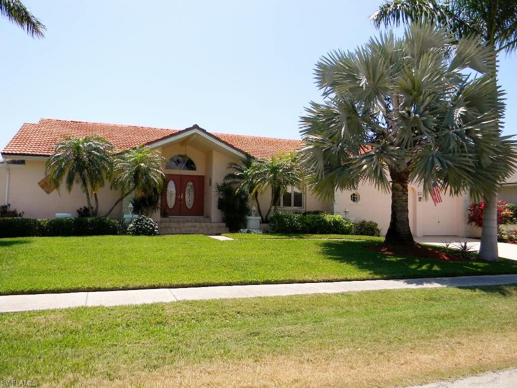 Beautifully updated and maintained waterfront home on Marco Island. Custom designed and built by current owner, this home has a lot of great features. Features include spacious rooms with cathedral ceilings, 3 BR, 3 full baths, tile floors throughout, 2 zone A/C system that was replaced in 2015, oversized pool (15 X 30), extended screened Lanai. Updates include new kitchen and master bathroom in 2015, tile floors replaced with 20" porcelain tile in 2016, MBR floor replaced in 2016, windows replaced in 2015. Floor plan offers large rooms and great flow for entertaining. The spacious Family Room provides lots of natural light and a built-in dry bar with mini fridge. The kitchen features maple cabinets, granite counters & stainless appliances. The Master Suite features 2 big walk-in closets, walk-in shower, private patio, dual sink vanity and new fixtures. Guest Bedroom also has a generous walk-in closet and tile floors. Large closet in hall near kitchen can be used for storage or as a pantry. 3rd Bedroom is currently being used as a den with built-in cabinets and Murphy bed. Great boating with a large dock & lift and less than 5 minutes to the Marco River and Bridge.