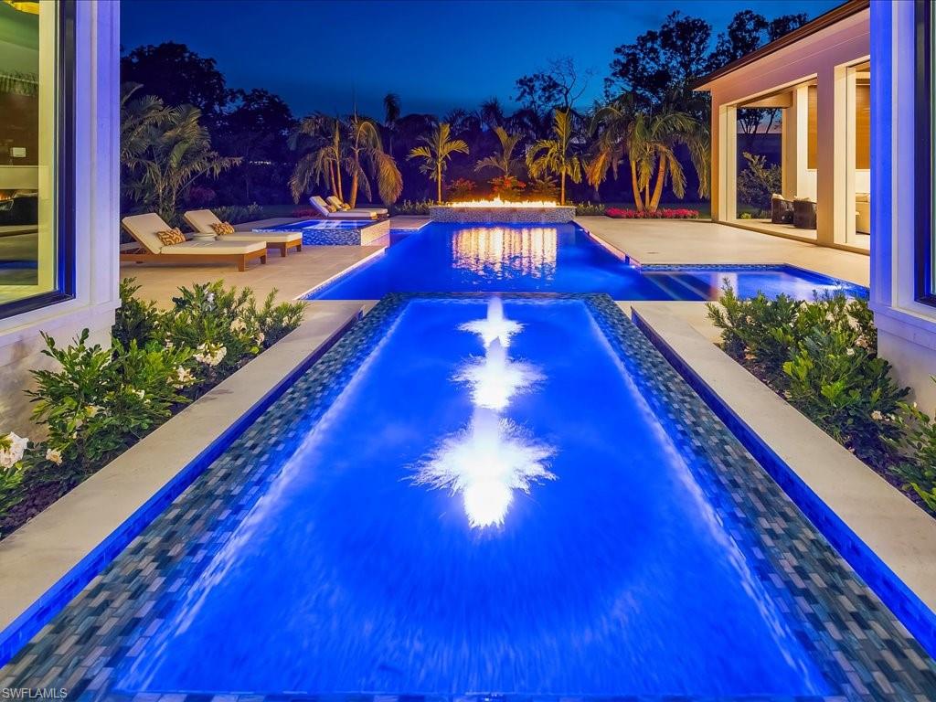 Poised as a singular architectural statement within Pine Ridge, 208 Hickory Road transcends the expected, offering a level of design, scale, and presence that is rarely achieved and not easily replicated. Encompassing over seven thousand two hundred square feet under air, this newly completed estate is not simply a residence, but a carefully orchestrated living experience where every detail has been considered with intention. From the moment of arrival, the home reveals a quiet confidence—clean lines, voluminous spaces, and a seamless interplay of light and texture. The open-concept layout unfolds with purpose, creating an effortless flow between formal and casual living. Six bedrooms, a private office, and a fully equipped gym are integrated with a sense of balance, ensuring the home lives as beautifully as it presents. At its core, the kitchen is both sculptural and highly functional, anchored by bespoke cabinetry, premium appliances, and a design that invites gathering without compromise. Surrounding spaces are layered with refined materials, custom millwork, and thoughtfully selected lighting, creating an atmosphere that feels both modern and enduring rather than trend-driven. Walls of glass dissolve the boundary between indoors and out, revealing a resort-caliber outdoor setting designed for both scale and serenity. The pool and surrounding terraces are framed by lush landscaping, offering privacy while still embracing the openness that defines Pine Ridge living. Set on a prime homesite just minutes from Naples’ most coveted destinations, this property delivers a rare combination of location, craftsmanship, and architectural clarity. For those seeking something truly distinct—where design, livability, and presence converge—208 Hickory Road stands apart in a way that is immediately felt and not easily forgotten.