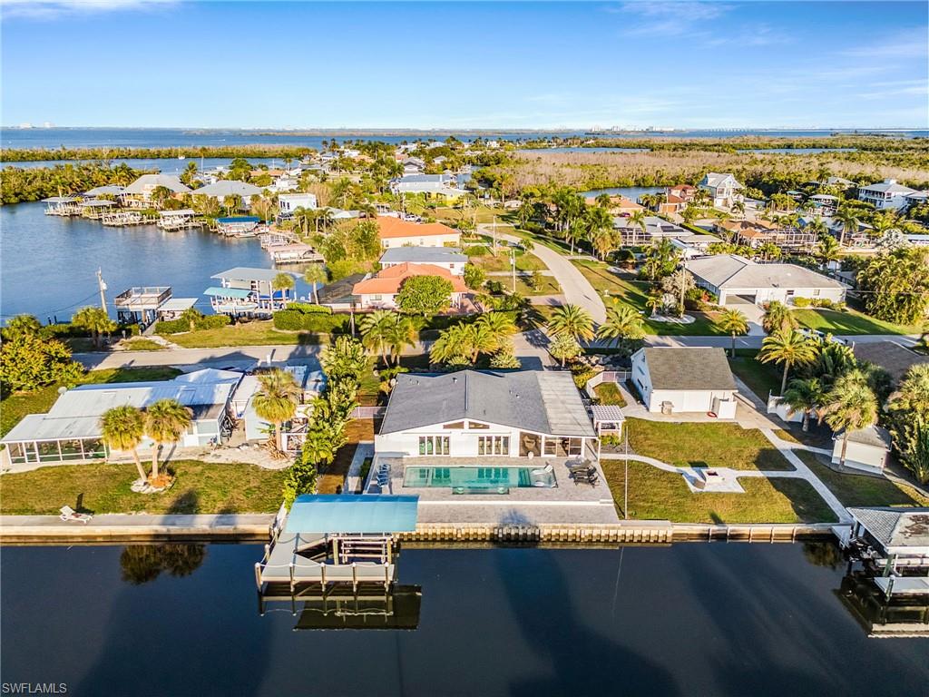 This is a unique and gorgeous waterfront paradise and a true boater's dream! Situated on nearly a HALF-ACRE in the heart of St. James City, this exceptional property offers the ultimate island lifestyle with 176 feet of waterfront and quick access to open water. 

The property features TWO covered boat lifts, one 20,000# and one 8,000#, making it effortless to launch your next fishing or boating adventure.  Outdoor living takes center stage with a resort-style pool and spa, and a cozy fire pit—perfect for entertaining family and friends while enjoying beautiful waterfront views. A detached garage with a loft provides abundant storage and flexible space for hobbies and all your fishing gear, while the dedicated RV parking area with hookups offers added convenience for travelers and visitors.  There is a separate fish shack for working on your fishing gear or relaxing with friends bragging about the day's catch.  

Whether you're an avid fisherman, boating enthusiast, or simply seeking a private waterfront retreat, this one-of-a-kind home on a double lot in St. James City delivers the ultimate island life-style.