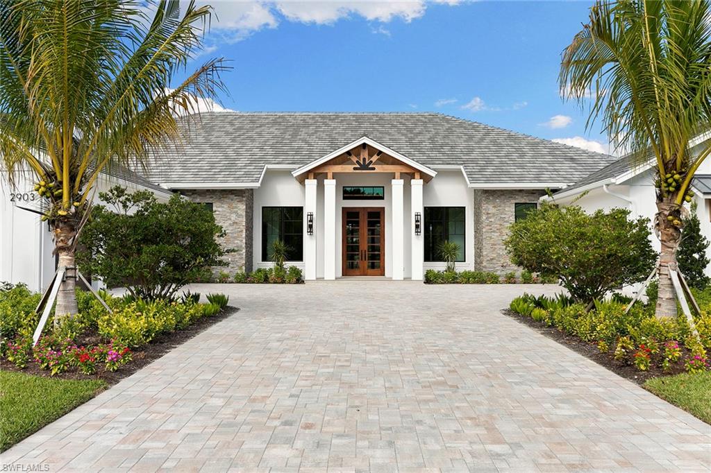 Welcome to Anthony Court and a new Naples estate designed for the way you actually live. This is the kind of home that gives everyone room to breathe, gather and spread out, with five bedrooms plus a spacious family, flex or game room that easily becomes your movie lounge, gym, office or wellness room. This is a big-home lifestyle without the big-home hassle, set against a serene lake view that instantly shifts the pace of your day. The real luxury here is location, minutes to the beach, Mercato and Waterside Shops, with public and private schools, dining, shopping and library close by, so daily life stays simple and spontaneous. Because estate living should come with autonomy, you'll love the freedom that comes with a non-HOA feel, the privacy of an in-town estate acre setting and flexibility to live on your terms. For the buyer who appreciates function as much as beauty, the five-car garage is a standout, with room for up to 10 cars with lifts, ideal for collectors, beach toys, golf carts and guests. Whether you live here full-time or come and go, Anthony Court offers the rare balance of lock-and-leave ease and estate scale, all in a location that keeps you close to the best of Naples.