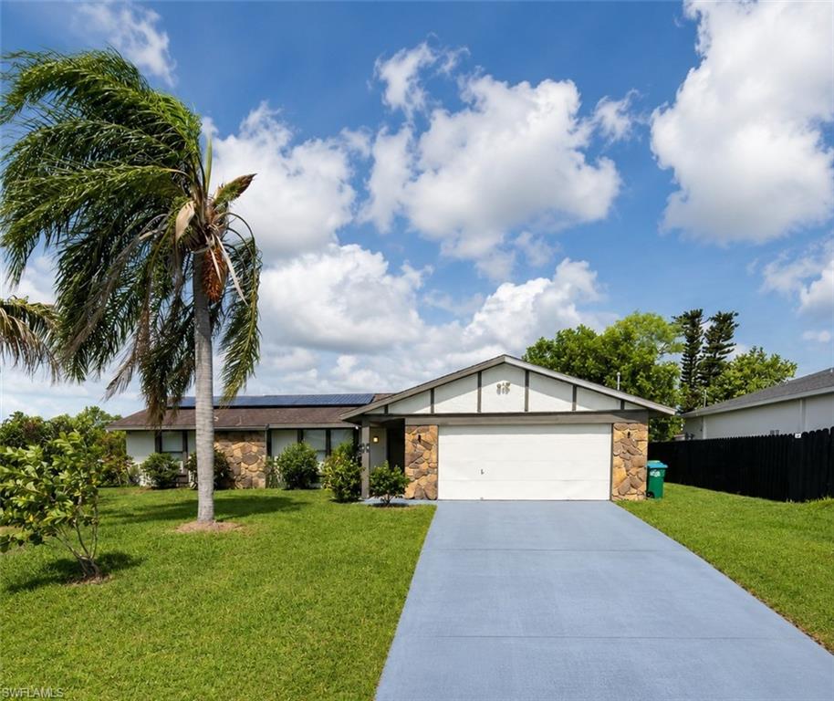 What if your own backyard could feel like a little piece of tropical paradise? Welcome to this inviting 3 bedroom, 2 bath Cape Coral home, where thoughtful updates, energy saving features, and unique touches come together to make this property something special. Step inside to a welcoming living room that greets you as you enter the home, along with a separate dining room and a comfortable family room located just off the kitchen. With multiple living spaces, there’s plenty of room to spread out, entertain, or simply relax. The split bedroom layout offers added privacy, with the primary bedroom featuring its own private bath and walk in closet. Outside, an extra-long concrete driveway provides plenty of additional parking and leads to a spacious 2 car garage, offering extra room for vehicles, storage, or hobbies. The fenced backyard brings a little taste of the tropics right to your doorstep, with an impressive collection of established fruit trees and plants, including mango, avocado, papaya, coconut, guava, banana, lemon, pomegranate, soursop, star apple, Spanish lime, and more. Pick fresh fruit from your own backyard, enjoy your morning coffee, or simply relax and soak up the Florida sunshine. There’s plenty more to appreciate. A fully paid solar panel system offers the potential for greater energy efficiency and lower utility costs. The home also features a reverse osmosis system for enhanced water quality. Several important updates have already been completed, including a new roof and A/C in 2023, a recently installed well pump, and a water heater replaced in 2021. Conveniently located near shopping, dining, parks, major roadways, and all that Cape Coral has to offer. With multiple living spaces, a split bedroom floor plan, valuable updates, paid solar, generous parking, a 2 car garage, and a fenced backyard filled with tropical touches, this home has so much to offer. Come see it for yourself and discover what makes this Cape Coral home such a special find!