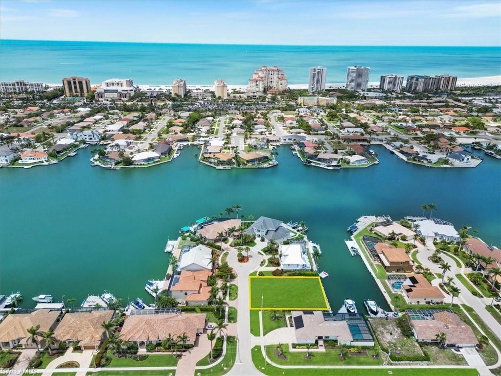 Yes, that is the white sand of Crescent Beach you see and this is the lot you have been waiting for. Waterfront Indirect Gulf Access, this approved building site is truly worthy of becoming your new Marco home. Oversized lot with dimensions of 90x110 ft, 9808 sq ft. Located on the short end of the Bond Court cul-de-sac, enjoy a small community of only 6 total lots on this section of the street. This is the last available for building, as the tip lot has been filled now. Time to make this your final winter season as a guest!