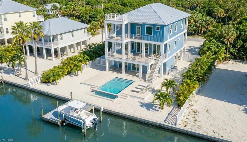 Exceptional new construction offering panoramic canal views and positioned on a weekly rental street with strong income potential. This elevated three-level  residence features 5 bedrooms and 7 bathrooms and is thoughtfully designed to accommodate up to 20 guests, making it one of the few homes of its kind on the island.

The home offers a short walk to the beach, canal access, and an oversized lot, blending luxury coastal living with flexibility for use as a primary residence, second home, or short-term rental. Outdoor living is maximized with a private pool and spa, an expansive rear deck capturing canal breezes, a garage-level tiki bar, and a rooftop deck with sweeping sunrise-to-sunset views.

Inside, the open-concept layout features custom furnishings, designer coastal finishes, and a spacious great room ideal for entertaining. The gourmet kitchen includes ample bar seating and flows seamlessly into a large dining area. The main living level offers a built-in bunk room with en-suite bath, while the upper level features four king bedrooms, each with its own private bathroom, providing comfort and privacy for guests. For buyers under contract early, there is potential flexibility to create a main-floor primary suite.

Offered fully furnished and rental ready, including furnishings, games, golf cart, ice machine, and more. With strong rental performance in comparable markets, and potential 1031 exchange. This property represents a rare opportunity to own a high-performing island home with exceptional lifestyle appeal.