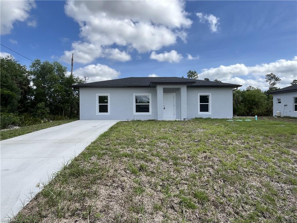 Welcome to your NEW MOVE-IN READY 3 BEDROOM 2 BATH HOME, located in the desirable Lehigh Acres, FL. This home is nestled in a private setting and boasts a large quarter acre lot with a spacious backyard. The open floor plan features an eat-in kitchen with granite counters, stainless steel appliances, plenty of cabinets, and a pantry. The great room/split floor plan concept provides ample space for relaxation and entertainment. The primary bedroom comes with an en-suite featuring dual vanities and a large tiled shower. All bedrooms are split for added privacy. The entire home is adorned with beautiful tile flooring and wood shaker cabinets, adding a touch of elegance. The open rear lanai is perfect for outdoor enjoyment. The home also includes storm protection-impact windows, and an inside laundry with washer and dryer hook-up. This pet-friendly home is ready for move-in and is one of the lowest priced 3 bed 2 bath homes in Lehigh Acres. Don't miss this opportunity to call this gem your home.
