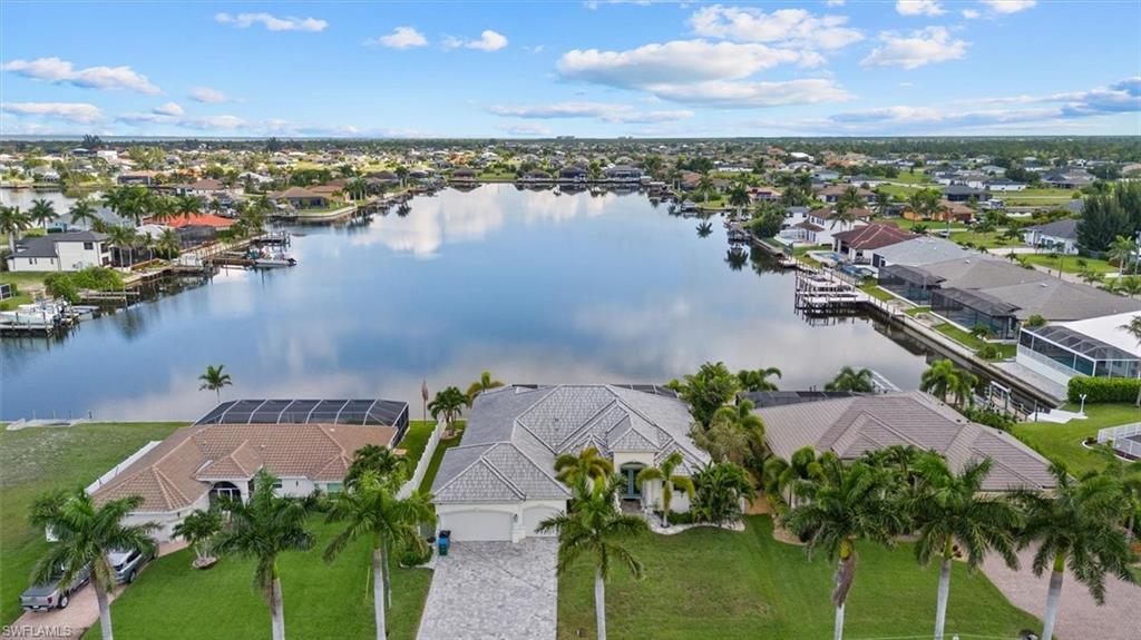 Gulf access, unobstructed lake views down the entire length of the waterway, and zero bridges to open water. SOLD TURNKEY. Welcome to 4227 NW 28th Street, a stunning 2018-built waterfront retreat in Northwest Cape Coral offering the kind of lifestyle most only dream about.
Situated on an oversized lot with 80 feet of saltwater canal frontage and direct lake views over Lupine Lake, this 3-bedroom PLUS DEN, 3-bathroom home delivers 2,526 square feet of refined living space with a 3-car oversized garage. Block construction, tile roof, impact windows and doors, and a paver driveway give this home the curb appeal and durability that sets it apart from anything nearby.
Step inside to soaring coffered and back-lit LED tray ceilings, crown molding, plantation shutters, solid wood cabinetry, and large format tile throughout. The open concept kitchen is the heart of the home featuring sealed horned granite countertops, a double built-in oven, Monogram cooktop and range hood, wine refrigerator, a large center island, a wet bar, and a dinning area with an additional set of sliders out to the pool. Picture window screening frames completely unobstructed, expansive water views from virtually every main living space, bringing the lake and canal backdrop into the home in a way that never gets old.
The primary suite is its own private retreat with pocker sliding doors leading directly to the spa, dual walk-in closets, a large soaking tub, and an oversized stone shower with dual shower heads. The split bedroom floor plan keeps guests comfortable and separate, while the den flex space works perfectly as a home office or fourth sleeping area. 
Outside, the screened lanai with picture window screening creates a resort-style setting around the heated saltwater pool and integrated heated spa. The outdoor kitchen is fully equipped for entertaining. The 3rd bathroom also acts as a pool bathroom with access to the lanai for ease of access. A vinyl privacy fence encloses the yard, mature landscaping and rock beds frame the property beautifully, and a lawn irrigation system keeps everything looking sharp year round. The large 3 car garage is also finished with an epoxy coating.
The entire home is served by a whole house reverse osmosis water system, delivering purified water to every tap and appliance throughout the property.
For boaters, this property is exceptional. The concrete seawall was built in 2018, there are no fixed bridges to the Gulf, and Matlacha and Pine Island are just a short ride away. The home has a proven track record as a high performing short term rental with no HOA restrictions limiting your options.
No CDD. No HOA. Turnkey. Gulf access. This one checks every box.