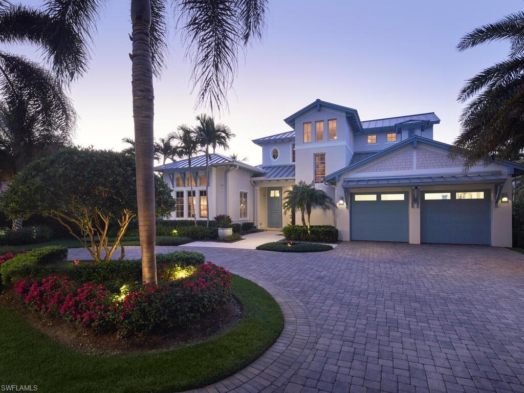Welcome to an extraordinary home that has been impeccably maintained and is conveniently located on a peaceful street in Old Naples. This residence, built in 2016 by London Bay and designed in collaboration with award-winning Romanza Interior Design, showcases a stunning blend of West Indies and Old Florida-inspired architecture, exuding exceptional curb appeal. The open great room plan features warm colors, exquisite finishes and furnishings, and thoughtful details throughout every space. The spacious kitchen includes built-in glass cabinetry, a breakfast nook, walk-in pantry, and a convenient built-in desk area, all complemented by a separate dining room for entertaining. Retreat to the primary suite, which allows for direct access to the beautifully landscaped backyard and boasts two walk-in closets along with a thoughtfully designed, light-filled bathroom leading to a remarkable private outdoor shower. Pocketing sliding glass doors in the main living area allow for an effortless flow to visually stunning and comfortable outdoor spaces including casual seating, dining, lounging area and fire pit.  Your guests will be delighted with two spacious guest suites and a cozy loft area on the second floor.  Situated in an X500 zone, this property sustained no damage from any storms and feels brand new.