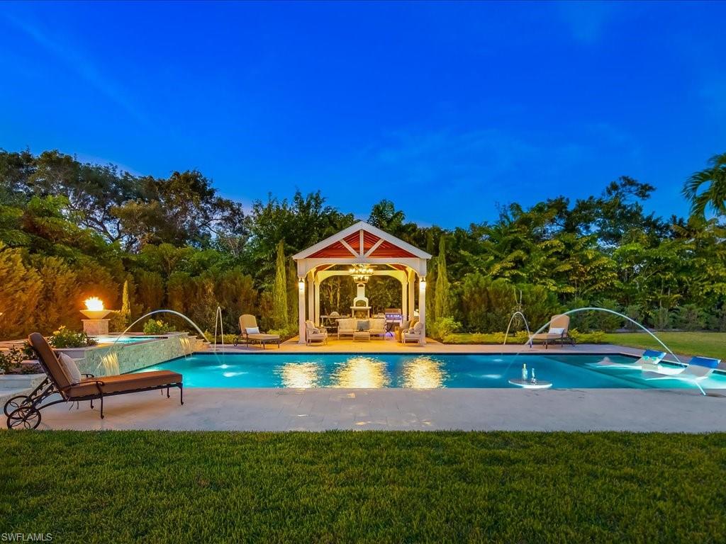 Set within the tranquility of Pine Ridge Estates, Six Twenty-Four Ridge Drive presents a masterfully reimagined coastal cottage offering refined comfort, privacy, and effortless Naples living. Fully remodeled from top to bottom, this four-bedroom plus den, four-bath residence encompasses more than three thousand three hundred square feet of air-conditioned living space, perfectly positioned on over an acre of beautifully landscaped grounds. A gracious foyer introduces the home’s inviting coastal aesthetic, where solid wood flooring, elegant wainscoting, chair rail detailing, and thoughtful millwork create a warm yet elevated ambiance throughout. The gourmet kitchen is tailored for the most discerning buyer, anchored by a coveted La Cornue range, dual Sub-Zero refrigeration, bespoke cabinetry, and an inviting breakfast nook overlooking the outdoor retreat. A beautifully designed bar area connects the kitchen to the main living spaces, creating a natural setting for intimate gatherings and relaxed entertaining. Formal and casual living areas offer versatility for every occasion, from elegant dinners in the formal dining room to relaxed evenings in the open and welcoming family room. The primary suite is a peaceful sanctuary with generous proportions, two spacious closets, and a spa-inspired bath featuring a soaking tub designed for unwinding in comfort. Three additional guest bedrooms provide privacy and comfort for family and guests. Outdoors, the expansive backyard unfolds as a private resort-style oasis. A newly created pool and spa serve as the focal point, complemented by a large, screened lanai ideal for morning coffee or evening cocktails. A charming gazebo offers additional covered space for alfresco dining, lounging, or hosting gatherings, all surrounded by open lawn and mature landscaping that provide exceptional privacy and endless possibilities for outdoor enjoyment. Move-in ready and ideally located minutes from beaches, shopping, and dining, this exceptional Pine Ridge Estates residence delivers timeless design, modern luxury, and an elevated Naples lifestyle. Schedule a private showing to experience the setting and scale of this remarkable property.