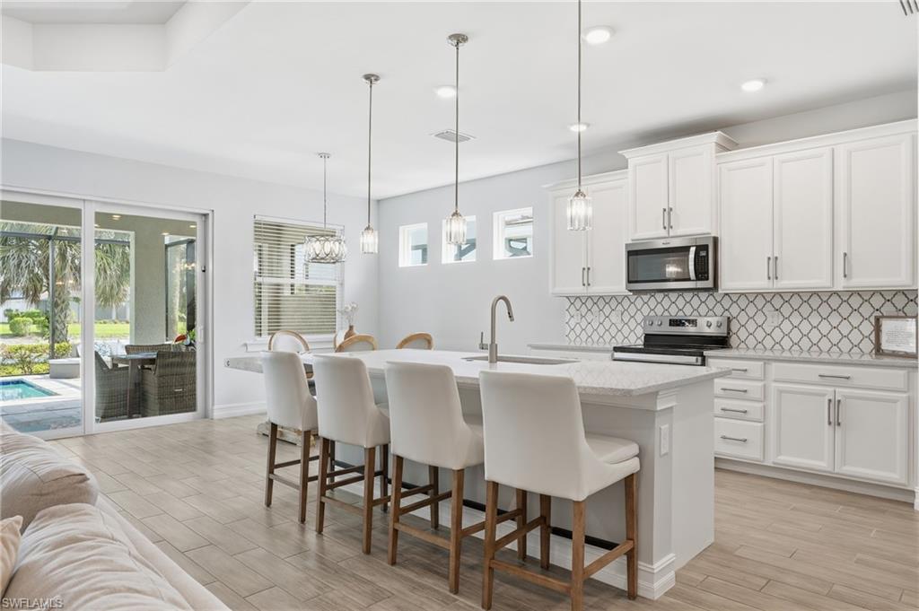 Presenting the popular "Shelby" floor plan in Seasons at Bonita! This bright, lake and fountain view, southern exposure home offers 3 bedrooms + Den and 4 bathrooms. Thoughtfully upgraded with tile flooring throughout, impact rated doors and windows, and a private heated saltwater pool & spa — ideal for year round enjoyment and low maintenance living. Open, light filled living spaces flow to the outdoor entertaining area, perfect for relaxing or hosting. Contemporary finishes throughout and well appointed baths provide comfort and convenience for family and guests. Seasons at Bonita is not in a flood zone, and offers resort style amenities including pickleball, tennis, bocce, fitness center, community pool, lap pool, hot tub, and two dog parks. A move in ready opportunity in a highly desirable community. Schedule your showing today!