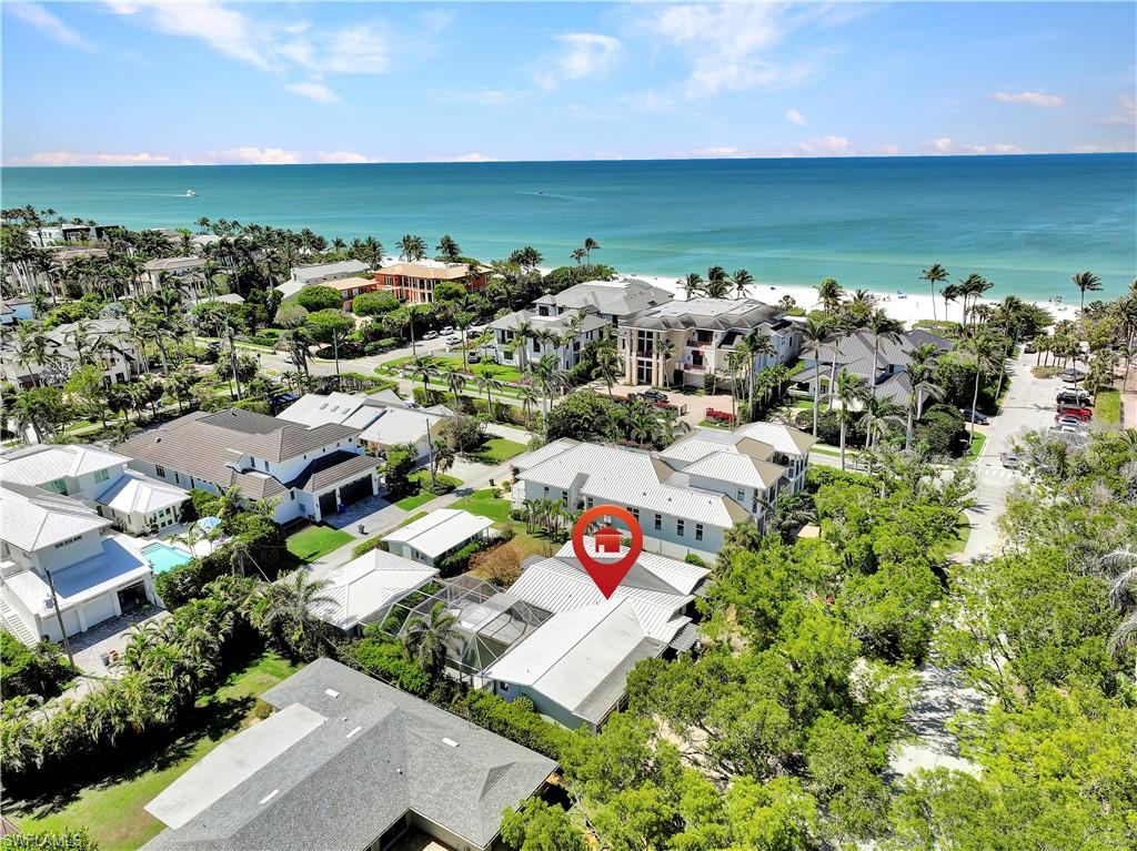 H9685. Nestled amidst the lush tree canopies of one of Olde Naples' most coveted streets, this property sits 3 houses from the pristine Gulf beach, beckoning you to indulge in the quintessential SWFL lifestyle. W/ coveted Southern exposure & rear alley access, this 100 X 150 (.34 acres) homesite offers a rare opp to build your dream home or transform the existing residence into a true masterpiece. This property boasts an esteemed location that is mere blocks from the upscale shopping & dining of 5th Ave S. Stroll, or bike to the historic 3rd St S shopping district, or take a leisurely walk to the Naples Pier or the future Four Seasons Beach Resort. This property features a 4 BR, 4.5 bath home w/ a 4.5 car garage, a screened in pool, & a 1 BR, 1 bath guest house complete w/ its own mailing address & utilities. All windows/doors are impact-rated. While the property was affected by Hurricane Ian, it presents a rare opportunity for the discerning buyer. No value is being attributed to the structures on the property. They are being sold in "As-Is" condition. The current owner has architectural plans for a 6,000 SF home, which are offered as a possible single level home on the site.