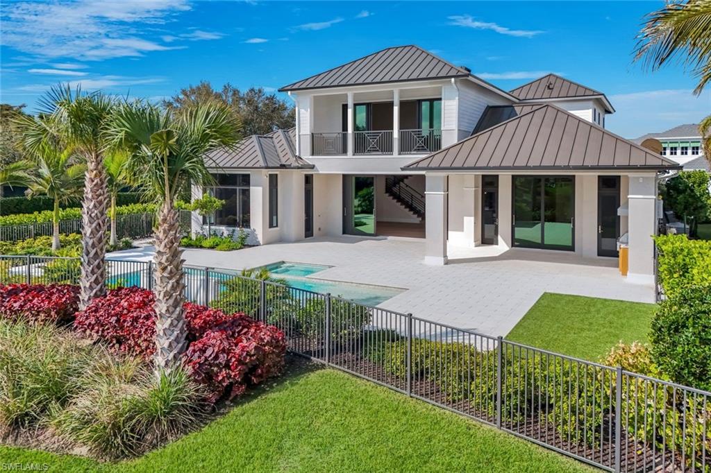 Discover a serene lakefront sanctuary in one of Naples’ most picturesque gated communities. Winding brick streets and lush, thoughtfully designed landscaping lead you to this stunning corner-lot home, where indoor and outdoor living blend effortlessly. The expansive lanai invites relaxation and entertaining with a sparkling pool, spa, and fully equipped outdoor kitchen, all set against tranquil lake views. A fenced yard and open green space offer a safe haven for children and pets to explore. Inside, the gourmet kitchen boasts GE Monogram appliances, while a striking wood-beam ceiling and cozy fireplace create warmth and charm. Perfectly positioned near Seed To Table, Gulf beaches, Mercato, and SW FL International Airport, this home combines convenience with the leisurely elegance of The Promenade lifestyle. This lakefront retreat is a true embodiment of comfort, sophistication, and effortless Florida living.