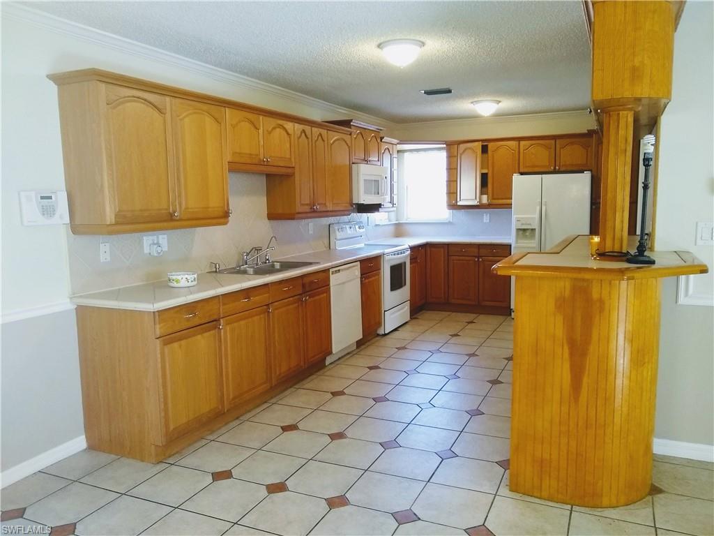 EASY TO SHOW: Start your fresh new life in this freshly updated home situated on a nice large wood privacy fenced back yard with very quick access to town. Wide 104' across the front. This home is looking for somebody to come enjoy it. 3 bedrooms with 3 bathrooms plus an extra kitchen area with private door leading into it. This dual kitchen house is EXCELLENT for someone needing a mother-in-law suite with private exterior entrance. The kitchen is designed for that entertaining Master Chef with super extra wide aisle and extra complimentary serving area. Master bedroom with walk-in closet. Don't forget the 25' x 16' screened porch for great entertainment. Plus extra storage in the 12' x 12' secured shed. Carport behind privacy fence to park your truck with all your tools. And double-wide front driveway area. Close to schools and parks. Come make this house your home.