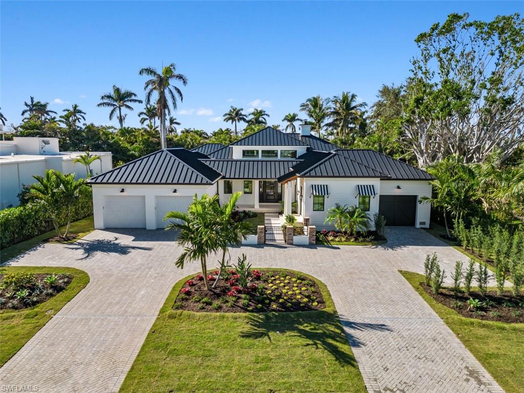 OUTSTANDING CURB APPEAL. Located on one of the most desirable streets in The Moorings, the unique one of a kind design of this single story home starts with the gated courtyard entry and continues throughout with an ideal floor plan and superior use of space. Taking full advantage of natural architectural elements, this 5 bed+study, 3 car garage home offers captivating character with French doors leading to the outdoor living and entertaining space with fireplace and pool bath. Inside, clerestory windows streams light into the great room highlighting exposed beams and lime-washed reclaimed brick. Generous use of light wood trim and rift cut cabinetry, paired with white oak and limestone flooring makes this home as warm and comfortable as it is luxurious. Fireplaces in the great room and outdoor area elevate the ambiance. The master suite enjoys access to a private garden oasis complete with water feature and outdoor showers. For your peace of mind a generator and 1000 gal propane tank that supplies the pool, spa, outdoor kitchen, Kitchen stove, indoor and outdoor fire place. Enjoy the sun from both a stone deck and green space along side the expansive pool with sunshelf and spa. All made possible by this large 0.39 acre south rear facing lot , the 6,500 + sq/ft home offers plenty of space under roof. Spinnaker Dr. is a quiet street south of Mooring Line Dr and a short stroll to the just opened Four Season Resort. This amazing located residence located W of Crayton and it allows for a short walk or bike ride to the neighborhood private gated beach park ( only 900 yards away) and The Moorings Country Club.  Architect Jeff Harrell & Associates, Design by Edom, and built by J. Sweet Construction.