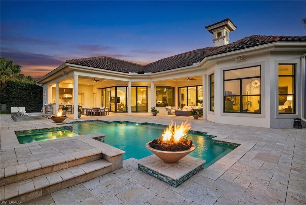 Set on one of the largest lakefront homesites in the community, this timeless 4 Bedroom residence plus a private office and 4 and a half baths offers the perfect blend of modern elegance and relaxed Florida living. Soaring ceilings and a beautiful mix of new wide plank light oak hardwood and tile flooring creating an airy, refined feel from the moment you enter, with spaces designed to transition seamlessly from formal gatherings to everyday comfort.  

Entertaining is effortless with a separate dining room and a custom wet bar complete with a wine cooler—ideal for hosting guests. The kitchen is a standout, featuring rich wood cabinetry, a center island, a walk-in pantry, 2 more wine coolers, and premium Viking appliances, including a natural gas cooktop. Casual dining is easy with bar seating and a sunny breakfast nook framed by a bay window overlooking the expansive outdoor living space.

The heart of the home is the family room, where high-impact pocketing sliders open wide to a spectacular resort-style lanai. Outside, enjoy true indoor-outdoor living with a full bar, outdoor kitchen, sparkling pool and spa, and dramatic fire bowls that set the scene for unforgettable evenings.

The primary suite is a peaceful retreat with a luxurious bath offering a separate soaking tub, walk-in shower, dual vanities, and designer lighting. Throughout the home, you’ll find thoughtful architectural touches including niche's  and extensive closet upgrades. Three additional bedrooms are configured as private en-suites, each offering comfort and privacy for family or guests.

Additional highlights include reconfigured pavers, new landscaping and landscape lights, new high-hats and dimmers throughout, a spacious laundry room with abundant cabinetry, sink, and built-in ironing board. The oversized three-car garage offers excellent storage, an air-conditioned closet, and even an additional washer and dryer—perfect for busy households and seasonal living.

Located within Mediterra, one of Naples’ most prestigious luxury communities, residents enjoy world-class amenities including two Tom Fazio championship golf courses, tennis, pickleball and bocce, a state-of-the-art fitness center, and miles of scenic biking and jogging paths. Dining is elevated at the private country club, while the exclusive Mediterra Beach Club delivers a true Gulf-front experience with a two-story, 10,000-square-foot facility featuring indoor and outdoor dining, a heated pool, sundeck, and full cabana service with chairs, umbrellas, and refreshments.

This is a rare opportunity on an oversized lakefront lot in Mediterra—where elegant living meets resort-style amenities.