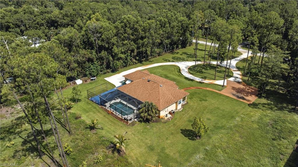 Experience the ultimate Naples lifestyle with this beautifully maintained 3-bedroom, 2-bath, 2-car garage pool home, nestled on 2.5 acres of peaceful, private land. Located in one of Naples’ most desirable areas, you’ll enjoy easy access to beautiful beaches, downtown, and those famous Gulf Coast sunsets—all while enjoying the quiet and space of country-style living. Privately set back from the road, the home features a long driveway leading to a roundabout parking area—perfect for welcoming guests comfortably. The spacious 2.5-acre property offers endless options for outdoor fun: space for kids to play, hobbies, gardens, or simply relaxing in your own private retreat within Naples. Inside, the home offers 10-foot ceilings, 8-foot doorways, tray ceilings, and wood and tile floors throughout. The kitchen is both modern and functional, with stainless steel appliances, raised panel cabinetry, and a stylish backsplash. A split-bedroom floor plan provides privacy while keeping living spaces open and connected—ideal for family life or entertaining. Step outside to enjoy the oversized 14x24 pool and extended lanai—perfect for family time, weekend get-togethers, or quiet evenings under the Florida sun. This home offers the best of both worlds: peaceful, private living with everything Naples has to offer just a short drive away. Don’t miss your chance to own this private slice of paradise