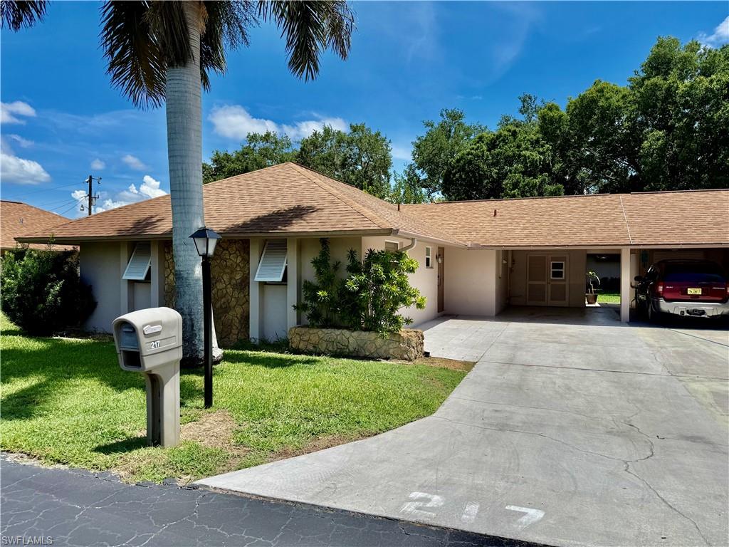 Affordable 2 bedroom 2 bath GOLFWOOD 1 Villa, NEW DIMENSIONAL SHINGLE ROOF IN 2017, NEW RHEEM CENTRAL HEAT AND AIR IN 2024, ceramic tile floors throughout with wood laminate in the bedrooms, 20 X 12 enclosed family room/den or entertainment space, fully insulated and under air, the utility room off of the carport has been expanded to provide more space for workshop or storage, covered carport plus additional parking, quiet low traffic street with wooded area in the rear for additional privacy, newer front entry door for extra lighting, kitchen and baths are in need of updating but priced accordingly, 55+ community, low monthly fees, excellent location within walking distance to Lehigh Trailhead Park, stores etc., central water and sewer. THIS VILLA IS PERFECT FOR THE HANDYPERSON THAT CAN UPDATE IT AND MAKE IT THEIR OWN. BEING SOLD AS IS.  NO FLOOD INSURANCE REQUIRED. LEHIGH IS LOCATED IN THE HIGHEST ELEVATION IN LEE COUNTY.