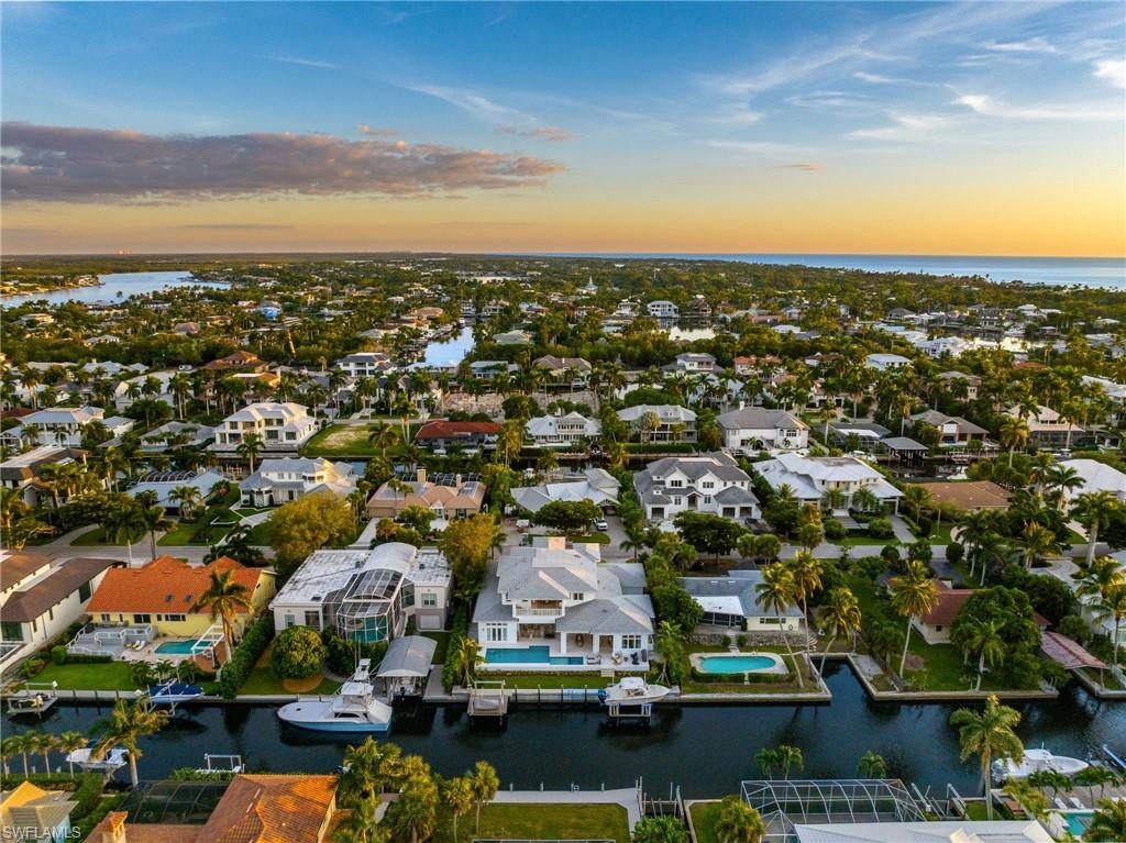 Built in 2022 and never lived in this extraordinary custom-built waterfront, like new, home is situated in Aqualane Shores offering quick and direct deep access to the Gulf of Mexico. With over 8100 total Sq.Ft. of living space, this home's open floor plan offers incredible indoor/outdoor living spaces, five bedrooms, each with en-suite bathrooms, offering privacy and convenience for residents and guests, whole house generator,  pool and powder baths, and a private elevator. The first floor features two master suites with luxurious walk-in showers, free-standing soaking tubs, dual sinks, and a vanity area. Modern design and décor can be found throughout the home, showcasing floor-to-ceiling windows, pocketing sliders, a 2nd-floor wet bar and relaxation area, and a true chef’s kitchen with top-of-the-line appliances. Entertaining is a breeze with expansive outdoor living encompassing an amazing pool and spa, a full kitchen with a gas grill, bar seating, a dining area, and an outdoor fireplace. This location is highly desirable, with a short walk to the beach and the historic Third Street South shopping and dining district. Despite its accessibility, the property is situated on a quiet, non-through traffic street. Overall, this waterfront luxurious home is a well-appointed property, offering a comfortable and elegant Florida lifestyle.  Only 899 steps to the beautiful white sandy Naples beach!