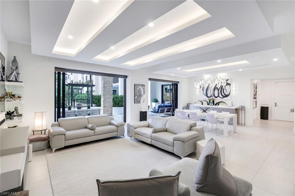 Rarely available southern-exposure, courtyard-level Emerson model featuring an extended lanai providing a total of  3,464 square feet of refined indoor-outdoor living. Thoughtfully designed with no detail overlooked, this residence welcomes you with an elegant foyer that makes a striking first impression, showcasing luxurious tile flooring, custom ceiling treatments, architectural return vents, and designer lighting that flow beautifully throughout the entire residence.

The gourmet kitchen is a chef’s dream, appointed with premium appliances, including a gas cooktop, built-in wall ovens, and a dedicated Miele coffee station. Sleek white cabinetry is beautifully complemented by stunning quartz countertops, while a built-in wet bar with sink and wine refrigerator enhances both everyday living and entertaining.

The same level of craftsmanship extends to the primary suite and two guest bedrooms, each offering a private ensuite bath and walk-in closet. A versatile den with custom frosted glass doors provides the perfect space for a home office or reading retreat.

Additional highlights include two deeded garage parking spaces in the secured garage. Residents enjoy resort-style amenities, including a lush courtyard, pool and spa, fire pits, club room, and state-of-the-art fitness center. Ideally located in Naples’ vibrant Design District, just steps from premier dining, shopping, cultural attractions, and the beautiful white sand of Naples.