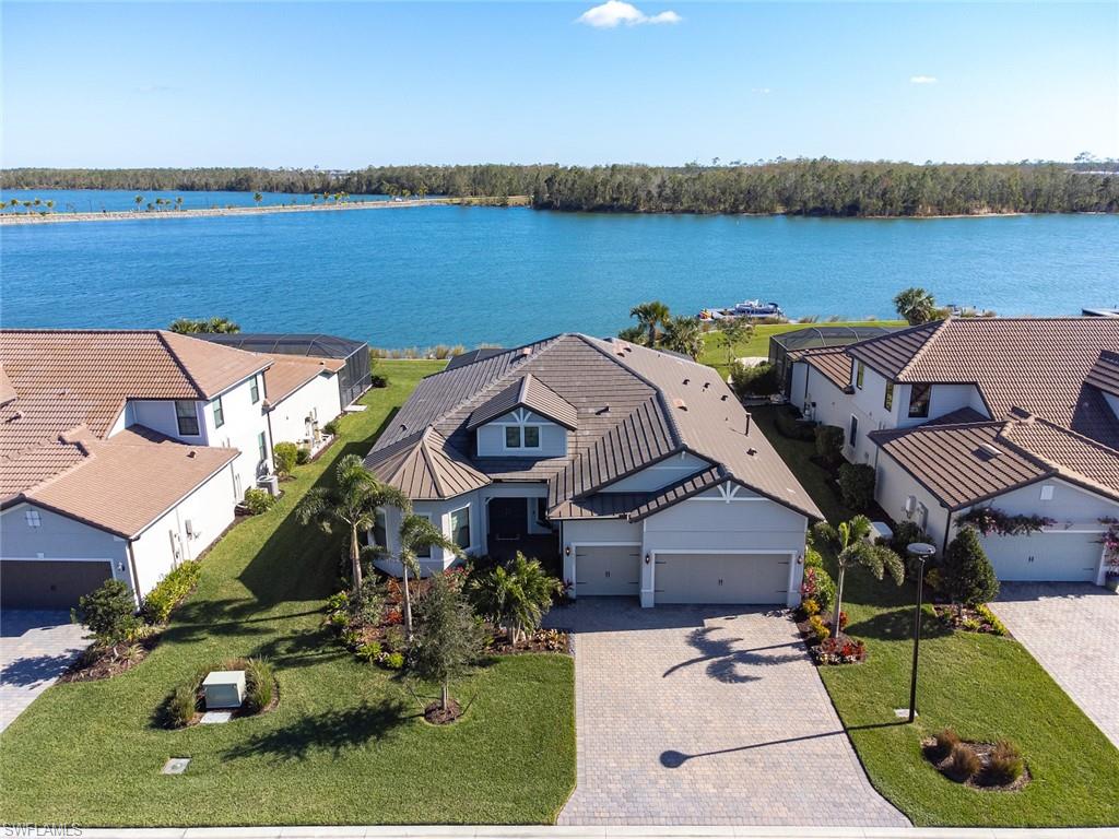 The BEST HOME you will find during your Fort Myers search, this luxurious lakefront home is located within the BEST COMMUNITY of WildBlue. Watch the walk-through video with extensive drone footage! View each of the 50 professional photos! Yes, this is the one. The picture window pool cage frames perfectly the open water view across a crystal-clear boating lake to the distant shore lined by natural Florida preserve. WildBlue is the luxury gated community of lakes adjacent to FGCU and Miromar Lakes, accessible from both south and north via Corkscrew Rd and Alico Rd. Technically it’s a great room concept, 3 bed, 3 bath with home office, 3-car garage, a pool, and a spa. Exceptionally it has impact windows and doors, quartz countertops, shaker cabinets, Premier Showcase outdoor kitchen constructed with StarBoard cabinetry, perfectly centered Trade-Wind range hood, Blaze grill with lighted controls, Generac 16kw generator, PENTAIR pool controls, and coffered ceiling. The air conditioned 24ft deep garage includes cabinetry and epoxy flooring by EncoreGarage. Roof is both tile and metal. Calling now is encouraged.