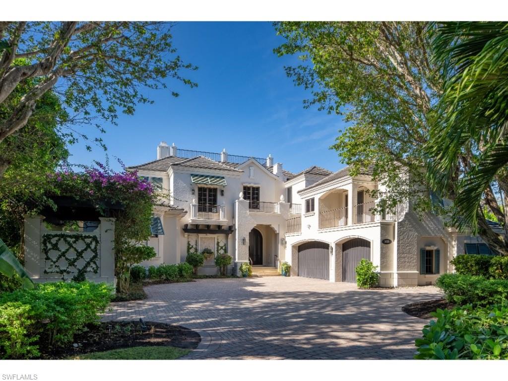 Positioned along Smugglers’ Bay with wide-water views and highly sought after western orientation, this distinguished Port Royal residence presents an enduring architectural presence and a thoughtfully configured floor plan designed for both refined entertaining and comfortable everyday living. A gracious entry foyer sets the tone, highlighted by a dramatic winding staircase that creates a memorable sense of arrival. A substantial wine room positioned beneath the stairway adds both architectural interest and elegance to the space. The formal living room overlooks the pool terrace and the water beyond, while the formal dining room’s design intentionally centers on views of lush greenery, offering a serene and intimate setting for gatherings. The inviting yet highly functional kitchen flows seamlessly into the family room, which extends naturally to the covered outdoor living areas, creating an effortless indoor-outdoor connection. Outdoor entertaining spaces are generous and well-positioned to take full advantage of the home’s exceptional waterfront setting. The primary bedroom suite is located on the first floor, along with a private office - both enjoying outstanding water views. The second level is dedicated entirely to guest accommodations and includes three exceptionally large guest suites, a secondary family room, an additional laundry room, and multiple balconies that allow guests to enjoy sweeping views of Smugglers’ Bay. For the boating enthusiast, the property offers a superb dock configuration with two lifts and no bridge access to the Gulf and inland estuarine waterways. Additional features include a three-car garage and a generator. Port Royal Club eligibility further enhances this offering, presenting a timely opportunity to secure a distinguished residence ahead of the anticipated opening of the new Port Royal Beach Club in late 2026.