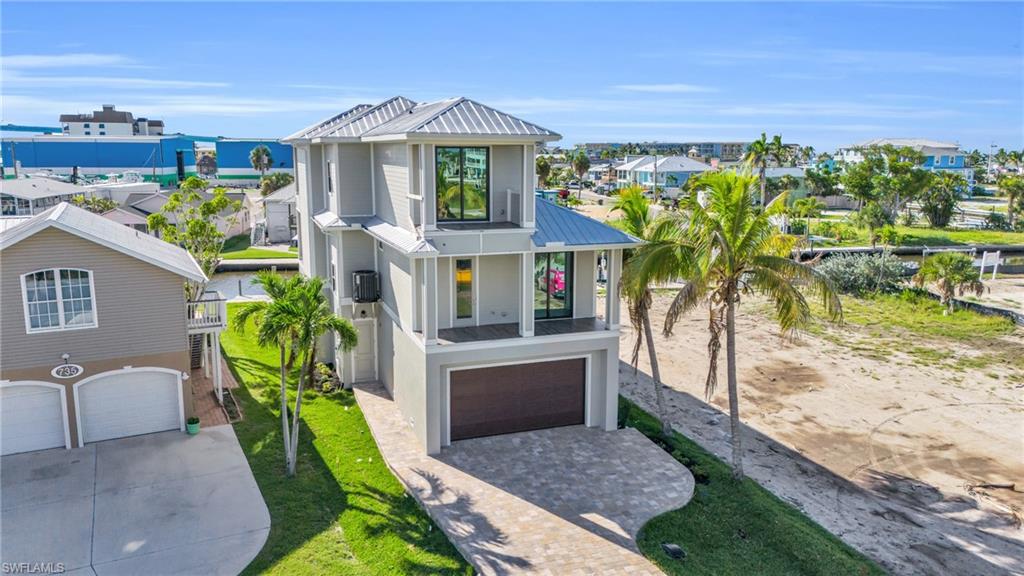 This Stunning Move in Ready NEW CONSTRUCTION Waterfront retreat offers endless views of Sunsets and the Boats on the Bay. CO'd and Ready for you to Enjoy, this ELEVATED POOL home Boasts an enviable location on the North end of Fort Myers Beach just steps from the sandy beach and a short walk to dozens of shops, bars, restaurants, the pier and Margaritaville. This Daniel Wayne built home offers an expansive floor plan that spans approximately 2,400 sq ft under AC of meticulously designed living space, featuring 4 bedrooms and 3 1/2 baths. Step into a world where every detail reflects refined craftsmanship and serene ambiance. The open concept kitchen flows seamlessly into the dining and living areas, creating a spacious and interconnected environment perfect for entertaining guests or enjoying family time together. Luxury upgrades such as Propane Gas & Monogram appliances and an Elevator. Each room is thoughtfully designed to maximize comfort and capture mesmerizing views. Offering amenities such as a 2 car garage and 4 Balconies to provide enchanting settings for every occasion—two dedicated to witnessing breathtaking sunsets that paint the sky with hues of orange and pink, and two designed for savoring the rhythmic charm of boats gliding by on the bay. The outdoor experience is equally captivating, with a Salt Water private pool & spa and a pool cabana that overlooks the gentle ripples of passing boats on the waterfront. Enjoy the convenience of Gulf access with no bridges, ensuring effortless journeys to nearby dining and entertainment hotspots by boat. Conveniently located within walking distance to the pristine beach, this is more than a home; it's a gateway to a lifestyle defined by coastal allure and unparalleled serenity. Embrace the essence of waterfront living and schedule your private tour today.