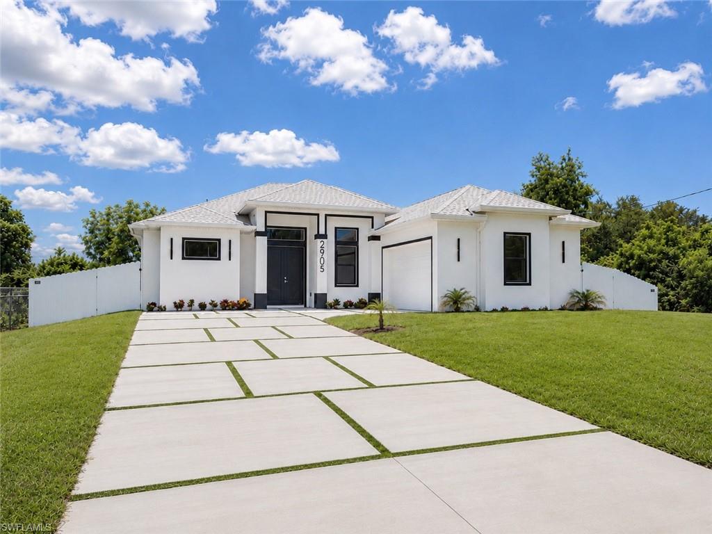 Enjoy the Florida lifestyle in this beautifully designed, fully fenced new construction home located just off Lee Blvd, minutes from Starbucks, Aldi, Chipotle, and many other everyday conveniences. This modern residence offers 3 bedrooms plus a den, 2 bathrooms, and a spacious side-entry 2-car garage featuring a finished epoxy floor.

The custom driveway with turf accents and modern exterior lighting creates outstanding curb appeal from the moment you arrive. Inside, you'll find an open-concept floor plan with polished 24x24 tile flooring throughout, soaring ceilings, recessed lighting, and a large designer fan in the main living area.

The kitchen features quartz countertops, stainless steel appliances, soft-close shaker cabinetry, pendant lighting, and a large center island with ample space for meal preparation and entertaining family and guests. Abundant natural light fills the home, creating a bright and inviting atmosphere throughout.

The spacious primary suite serves as a private retreat featuring dual vanities, an oversized mirror, a glass-enclosed walk-in shower, and elegant stone-look tile finishes. The guest bathroom offers matching modern finishes, providing a cohesive design throughout the home.

Step outside to the covered lanai, complete with two ceiling fans and plenty of space for outdoor dining, relaxing, or enjoying peaceful Florida mornings and evenings. Additional features include a laundry room with upper cabinets and utility sink, washer and dryer, impact-resistant windows and doors, quartz countertops throughout, and a full sprinkler irrigation system to keep the lawn looking beautiful year-round.

This home is brand new, fully completed, and truly move-in ready with no additional work needed. Conveniently located near SR-82, shopping, dining, schools, Florida Gulf Coast University, and Southwest Florida International Airport, this property is situated in one of the fastest-growing areas of Lehigh Acres.

An excellent opportunity for buyers seeking modern construction, premium upgrades, low-maintenance living, and plenty of space to enjoy everything Southwest Florida has to offer.