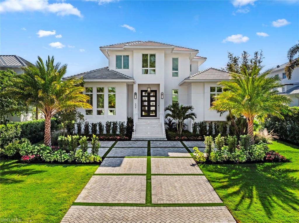Introducing 544 13th Avenue South — a newly completed Coastal Contemporary estate that sets a new standard for modern Old Naples living. The striking white façade, elevated entry, and meticulously curated landscaping create an immediate sense of presence and sophistication.

Designed by Falcon Design, crafted by Waterside Builders, and finished by Dianna Horsley Design, this residence offers 6,760 sq. ft. under roof and 5,436 sq. ft. under air, delivering a flawless blend of architectural excellence and refined livability. The thoughtful layout provides two main-level bedrooms, including a serene primary suite with spa-quality finishes, and a second bedroom that functions beautifully as a guest suite or dedicated office.

Inside, clean lines, designer lighting, and expansive windows fill the home with natural light. The gourmet kitchen is equipped with custom cabinetry, a large center island, top-tier appliances, and a discreet service kitchen ideal for hosting and catered events. The great room opens seamlessly to the outdoors through full-height sliders, creating effortless indoor–outdoor living.

The outdoor environment is truly resort-caliber, featuring a stunning pool with sun shelf, expansive decking, integrated seating areas, and a fully equipped summer kitchen — all framed by lush tropical landscaping for beauty and privacy.

Upstairs, a private guest suite with a balcony and kitchenette offers exceptional comfort for visitors. A spacious bonus room provides endless flexibility — perfect for a media lounge, gym, bunkroom, or additional bedroom. The second-floor serving bar opens to a large covered balcony overlooking the pool, creating an elevated entertaining space ideal for sunset gatherings.

Additional features include a three-car garage, full smart-home integration, a whole-house generator, custom millwork, and a 10-foot elevated front elevation for enhanced peace of mind.

Positioned just steps from Historic 3rd Street South, Fifth Avenue South, and the Gulf of America, this residence delivers the ultimate blend of craftsmanship, convenience, and the signature lifestyle that makes Old Naples so sought-after.

A brand-new, move-in-ready masterpiece — now complete and ready to be enjoyed!