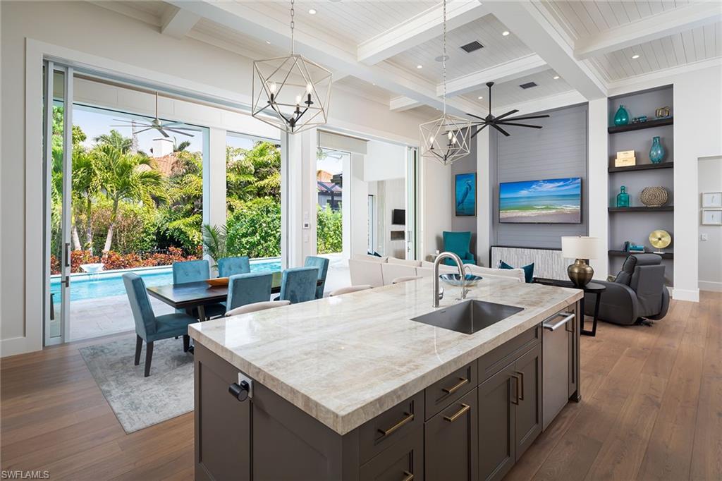 Situated in a spectacular West of Crayton location, this coastal-inspired residence was penned by R L Keith Architects and built by Trademark Development Group. Enjoy beautifully appointed one-level living with Legno Bastone floors and tongue and groove ceilings that soar to nearly fifteen feet. The primary suite, conveniently connected to the laundry room, boasts two expansive custom walk-in closets, a coffee bar, and a separate tub and shower. Additionally, the residence features a pool bath and an additional powder room, catering to both comfort and functionality. The magnificent great room is accentuated by a stunning two-sided gas linear fireplace shared by the conversation room and the adjoining office/study. The Epicurean kitchen offers bespoke cabinetry, a large custom pantry, and Thermador professional series appliances. The oversized lanai boasts automated screens and shutters, opening to the spillover pool and spa, and the outdoor kitchen with a fireplace provides a picturesque setting for gatherings and relaxation. The garage boasts high ceilings and doors, offering ample space to accommodate lifts for the car enthusiast.