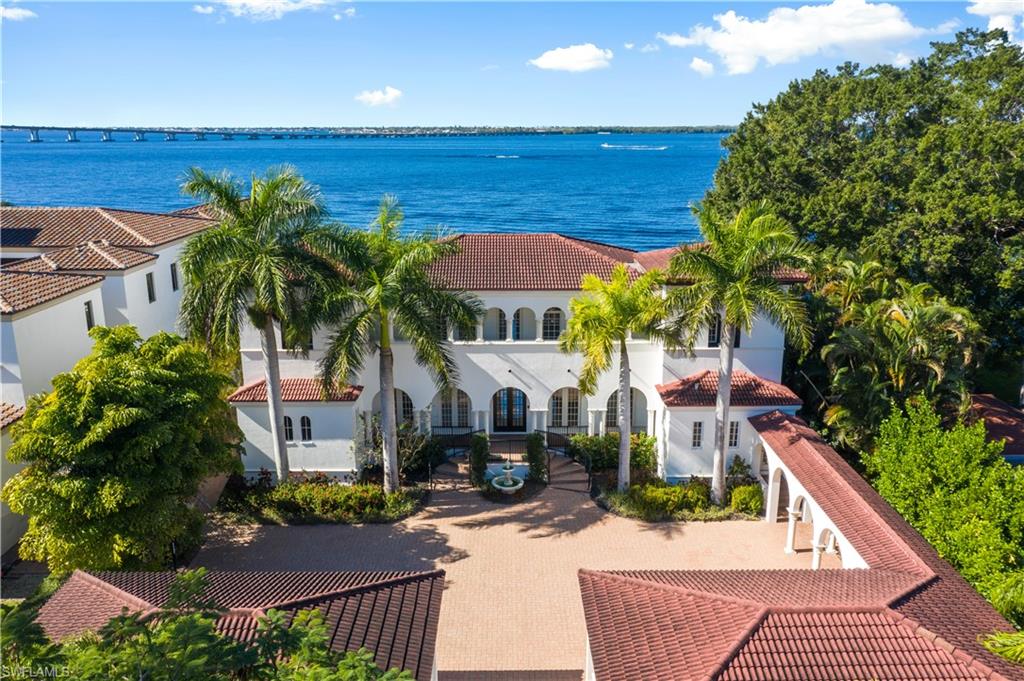 Welcome to this stunning W.A. Bud Lawrence designed estate. Situated on 2/3 of an acre, with over 100 feet of Caloosahatchee River frontage, this home offers an unmatched level of privacy and exclusivity. With over 5,000 square feet of living space, 4 bedrooms plus a den, 4 full bathrooms, 2 half bathrooms, formal and informal living spaces centered around an expansive chef’s kitchen and a large first floor master suite, this home lives extremely comfortably. With beautiful finishes and fixtures throughout, such as custom solid wood cabinetry, intricate woodwork, arched entryways, marble & hardwood flooring, and top of the line appliances, it’s apparent that no expense was spared in crafting this stunning estate. With an outdoor kitchen and large under truss seating areas that surrounds your infinity edge salt water pool that overlook the amazing wide water view punctuated with extraordinary sunsets, this home is built for entertaining. Upstairs offers 3 large guest bedrooms all with private bathrooms and 2 outdoor balconies, one looking over the river. In the front you're greeted by a private gated entry, a guard house, and a 4-car garage. A must see to truly appreciate.
