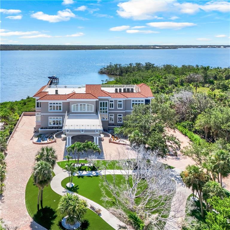 There are homes you can understand online, and then there are homes you must walk through to truly feel. This is one of them. A private Gulf Coast resort compound for collectors, entertainers, and legacy buyers.  Set on nearly 3 private acres along Lemon Bay, this gated Mediterranean-inspired estate spans 12,789 sq. ft. of resort-style living with unmatched amenities on Florida’s Gulf Coast, all within this private estate.  Enter through grand gates and follow a sweeping driveway framed by mature oaks, tranquil ponds, waterfalls, and curated sculptures. The grounds include manicured lawns, a putting green, bocce and volleyball courts, and expansive outdoor recreation.

A dramatic porte cochère introduces a soaring two-story foyer with double glass doors, stained-glass transoms, and a glass elevator. Interiors showcase coffered and tray ceilings, stately columns, marble and travertine floors, extensive millwork, and eight fireplaces.

The home offers six ensuite bedrooms, 9.5 total baths (primary bath has 3 bathroom sections but counted as 1 in the total), a library with wet bar, a media/family room with projector, fitness and meditation rooms, and rooftop terraces designed for sunset and Gulf views. The chef’s kitchen features dual islands, Sub-Zero and Wolf appliances, wine fridge, ice maker, and walk-in pantry, flowing seamlessly into both formal and casual dining areas. The primary suite includes bay views from a private screened terrace, fireplace, sitting area, spa-like bath, and custom closets, while guest suites offer private balconies, walk-in closets, and baths.

Outdoor living is highlighted by a 30×50 resurfaced saltwater pool and spa, full outdoor kitchen, shaded terraces, pool bath, and recreation courts. The property extends to a private dock with boat lift and deeded Gulf beach access. A tiled garage provides capacity for up to 30 vehicles, complete with 10 mini-split A/C systems and extensive storage, ideal for collectors or large-scale entertaining.