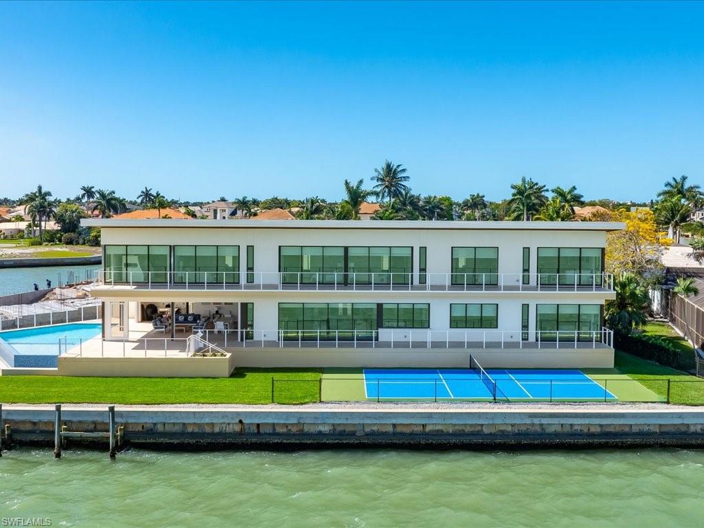 Discover modern contemporary architecture, clean lines, minimalist design features, high ceilings and glass walled rooms overlooking the open water. They define this new 2025/26 built 8,652 sq ft  (under roof; 6255 sq ft AC) home designed for groups, style and appeal.  An amazing 180 degree panoramic open view graces the living spaces, refreshes the senses day and night.  Eight bedrooms ( 7 ensuite) with 10 full bathrooms create comfort for your family, friends, or any group you invite.  Sunseeker heated pool and kids play area for soaking up tropical warmth on winter days, splashing, and bubblers with waterfall edge melting into the riverfront.  Outdoor living space features grill area, pool bath, and spacious entertainment or seating area that flows from inside living to the pool. Whether your yacht is 100 feet or you have multiple water craft nearly 200 feet of sea wall provide room for everything: yachts, in shore or off shore boats, multiple docks,  jet skis, kayaks.  Engineered with 44 roof top solar panels to power your home, 400 amp electric service, equipped with garage EV charger & 3 bay garage. Intentionally designed to create maximum views while keeping it cool inside. Large format porcelain floor tiles present style & grace. LED lights throughout balance light & color.  Large island kitchen for gathering means everyone is together. Air conditioned glass front & lighted wine display allows you to showcase your collection. Solid steel frame/concrete construction & elevation at 10 feet - designed for storm protection. Furnished or unfurnished as you like- your choice. A Marco ‘riverfront’ location for endless enjoyment and generational treasure