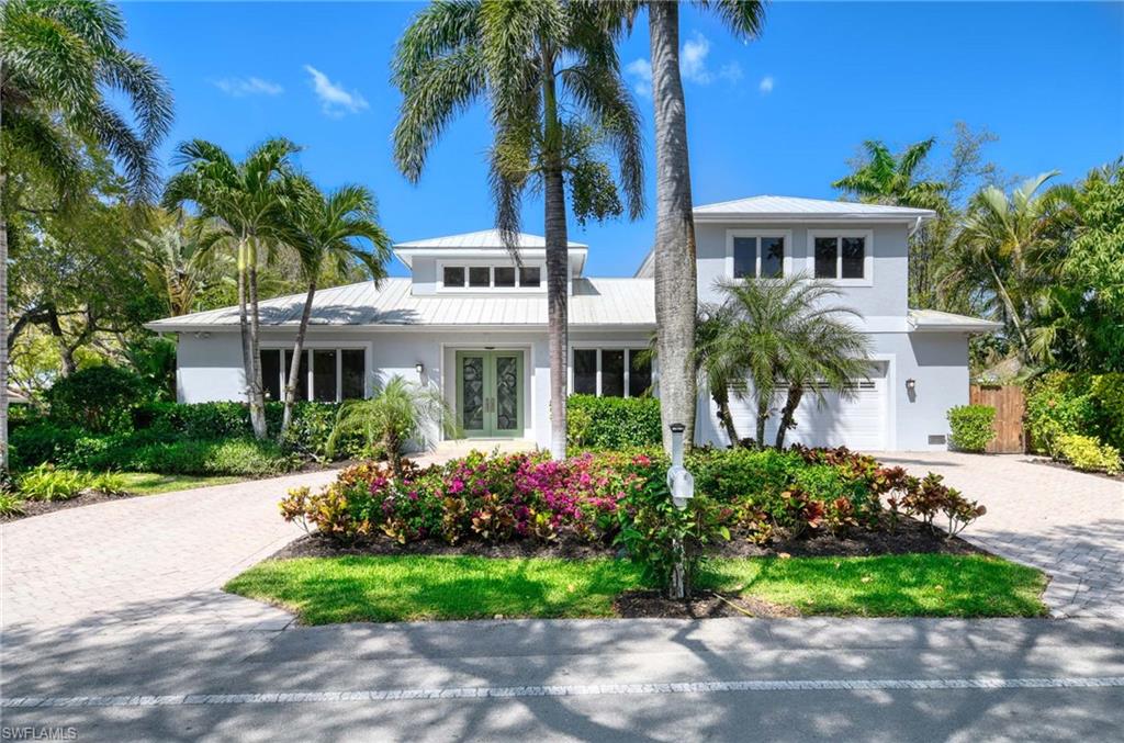 Built in 2012 and perfectly positioned in a coveted X500 flood zone, offering the peace of mind and exceptional appeal that come with its desirable elevated location, this home features three spacious bedrooms, including a first-floor primary suite and two private guest bedrooms on the second level. Thoughtfully designed and perfect for both daily living and entertaining with a versatile den on the main level for further flexibility as a home office, library, or creative space. Warm wood flooring flows seamlessly throughout, while tray ceilings with crown molding exude sophistication. The open-concept great room transitions effortlessly from the kitchen, which boasts stainless steel appliances, a central island with a breakfast bar, and generous storage perfect for casual dining or meal preparation. The first-floor primary suite is a private oasis, featuring a luxurious ensuite with a tub, walk-in shower, and dual sinks. Upstairs, the guest bedrooms are generously sized, offering comfort and privacy for family and friends. Outside is your private sanctuary, where a spacious covered lanai provides the perfect setting for tranquil evenings or lively gatherings. A sparkling pool, bathed in southern sunlight, is framed by a paver deck and lush, mature landscaping. With the beach just a short stroll away via 3rd Avenue North, you can enjoy breathtaking sunsets nightly. Practical features include a metal roof, a spacious garage, and a paver driveway, all adding to the home's curb appeal. Beyond the property, you’re moments from the best of Olde Naples.  World famous sugar-sand beaches, vibrant dining and shopping on 5th Avenue S, and nearby parks and cultural attractions. This home is more than just a residence, it’s a lifestyle. With its impeccable design, prime location, and array of comforts, this property offers a rare opportunity to experience the very best of coastal living.  A must see!