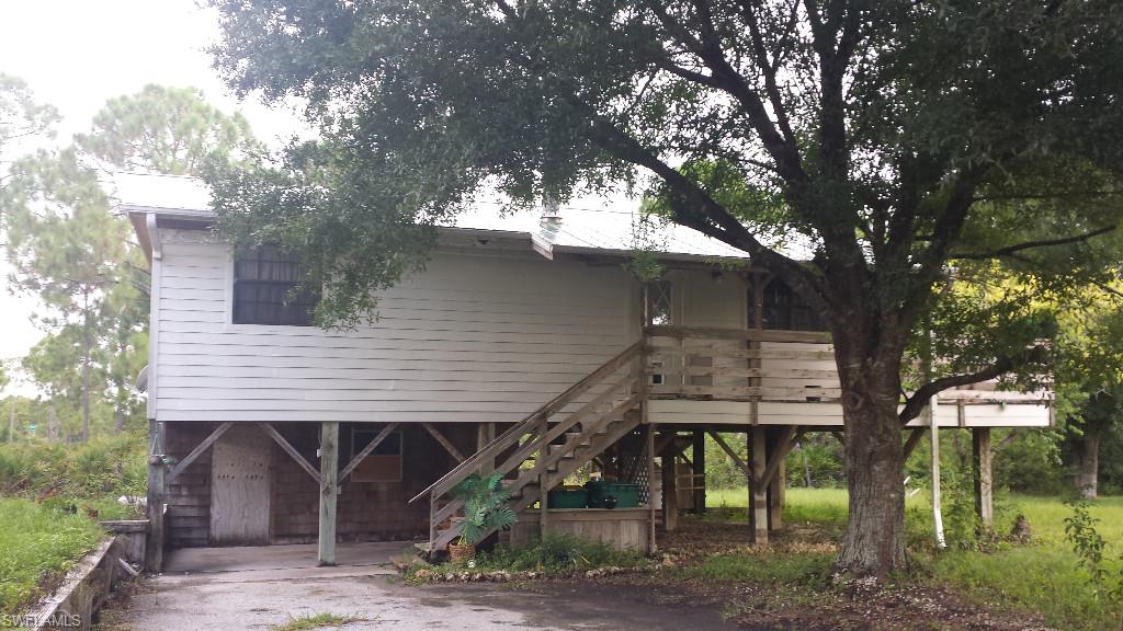Back on the Market!  Buyers loss is your gain to take advantage of this home that is situated on almost 1/2 acre, you will love the privacy it has!  Bring your boat or RV to this unique elevated 2 bedroom 1 bath home.  New RO system in place.  The kitchen has maple cabinets with tile counter tops.  You can enclose the bottom of the house for more room or have it for covered parking.  Mature trees on lot.   Brand New Electrical panel and breakers.   Schedule your showing today!!!