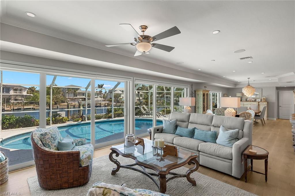 Discover a stunning, waterfront retreat, likely the highest ground-level home in the neighborhood. Designed for luxury and peace of mind, this outstanding property had no water intrusion during hurricanes Milton and Helene, according to the owner, offering security in a prime coastal location. Completely remodeled and thoughtfully designed for the ultimate Florida lifestyle, this three-bedroom, three-bath home, with a dedicated office/den, is ideal for entertaining. High-end finishes elevate every space, from elegant electric fireplace in the living room to custom built-ins in the family room. The spacious, open-concept kitchen is a chef’s dream, featuring high-end appliances, a gas range, and a large island ideal for gathering with friends and family. The private main suite is a tranquil oasis, boasting abundant natural light and serene water views. Its luxurious en-suite bath offers a custom shower, dual vanities and a large walk-in closet with built-in shelving. The spa-like guest bath, complete with dual vanities and a Jacuzzi tub, ensures comfort and indulgence for visitors. Outdoor living takes center stage with a beautifully enclosed pool area, ideal for year-round enjoyment and alfresco entertaining, all while soaking in breathtaking water views. Boating enthusiasts will love the deepwater, 150-plus-foot-wide canal, over 100 feet of seawall and private wrap-around dock with a 16,000-pound lift. easily accommodating a 14-foot-wide vessel. With no bridges to navigate, you’ll be just minutes from open bay waters. Amid lush, native landscaping, the expansive grounds create a peaceful, park-like setting. This is more than a home, it’s a lifestyle. Don’t miss the opportunity to own this exceptional waterfront gem.