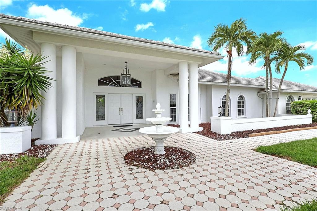 Welcome to a residence where timeless elegance meets effortless Florida living. Oversized property with Gulf access, intersecting canal views and just 15 Minutes boat ride to the river. From the moment you arrive, the grand columned entrance, circular fountain, and tropical landscaping create an unforgettable first impression, setting the tone for the luxurious spaces that await inside. Step through the double doors into a bright, open-concept floor plan highlighted by soaring ceilings, natural light and expansive living areas designed for both entertaining and everyday comfort. The home's impressive architecture features skylights, oversized windows, and seamless transitions between the formal and casual living spaces, creating an airy and inviting atmosphere throughout. The elegant living room opens effortlessly to the screened outdoor living area, blurring the line between indoor and outdoor living. A built-in wet bar provides the perfect setting for hosting guests, while the formal dining area offers an impressive backdrop for memorable dinners and celebrations. Thoughtful design details, custom finishes, and generous gathering spaces make this home ideal for entertaining on any scale. This exceptional property offers the perfect combination of sophistication, functionality, and Florida charm—an extraordinary place to call home. The spacious primary suite is a true sanctuary, featuring a spa-inspired en-suite bath with dual vanities, an oversized soaking tub, a walk-in shower, and natural light that creates a bright, relaxing atmosphere, providing a peaceful escape at the end of the day. Step outside to discover the home's showstopping private lanai, were indoor and outdoor living blend seamlessly. Enjoy morning coffee, afternoon gatherings, or sunset dinners beneath the expansive covered patio overlooking the screened pool & spa. Lush tropical landscaping surrounds the outdoor living space, offering exceptional privacy while framing tranquil water views that make every day feel like a vacation. Whether you're hosting family and friends or simply unwinding in your own personal paradise, this home delivers an unparalleled lifestyle with spacious travertine flooring living areas. Perfectly designed for those who appreciate beauty, comfort, and the very best of Southwest Florida living, this remarkable property is ready to welcome you home. New roof 2021. New plumbing, the house is completely re-piped 100% 2022. This house has a history of a successful vacation rental program. One-of-a-kind residence, schedule your private showing today, you will not be disappointed!