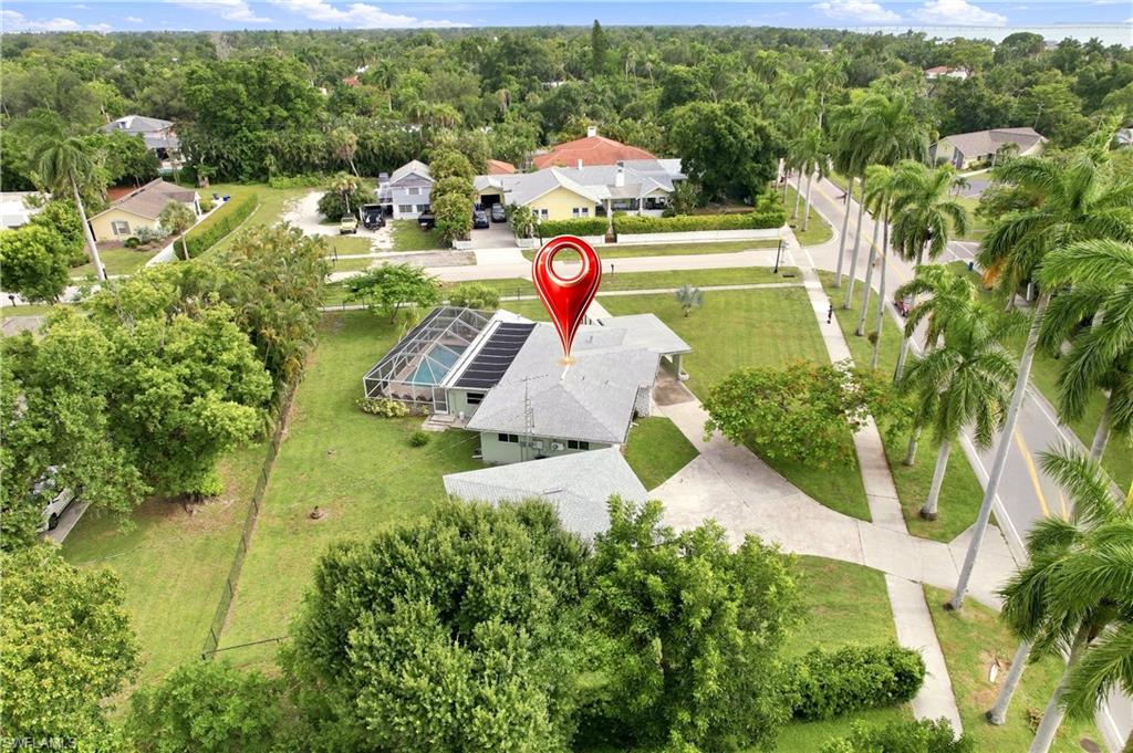 This home has never experienced flooding during any hurricane! Beautifully updated single-family home with screened pool, situated on an oversized corner lot. The property features a circular driveway, an attached carport, and a spacious detached 2.5-car garage complete with built-in shelving and cabinet storage. Inside, the remodeled kitchen showcases granite countertops, updated cabinetry, a stainless steel sink and appliances, a breakfast bar, under-cabinet lighting, and Lazy Susan. Recent improvements include updated plumbing and electrical wiring, hurricane-impact windows and sliding glass doors, a resurfaced pool, and a large screened lanai. The outdoor kitchen includes a smoker that has never been used. Both bathrooms have been tastefully renovated, and the home also features a newer air conditioning system and furnace. Walking distance to downtown!